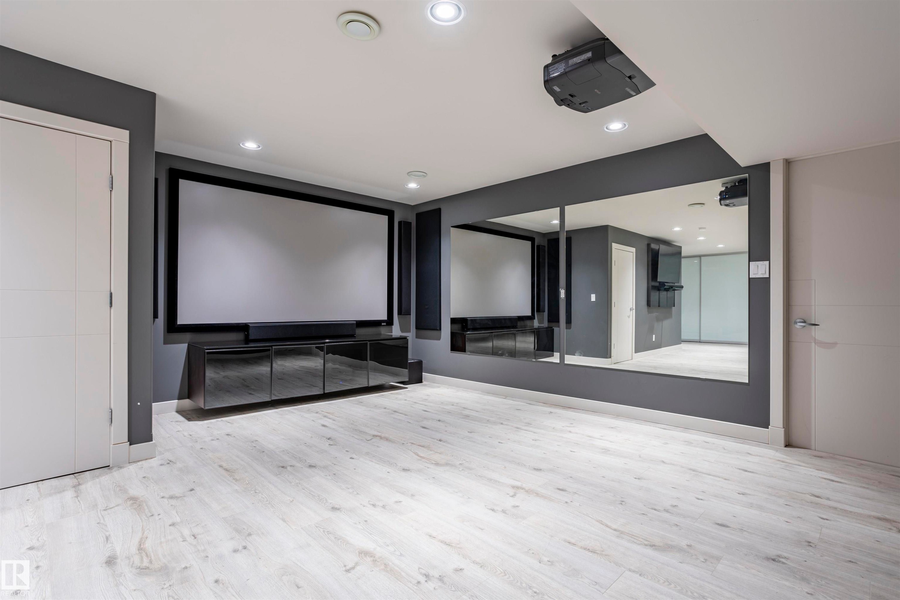 Dedicated media room featuring a large projection screen, ceiling-mounted projector, and integrated sound system - 4949 Terwillegar Common Nw, Edmonton, AB