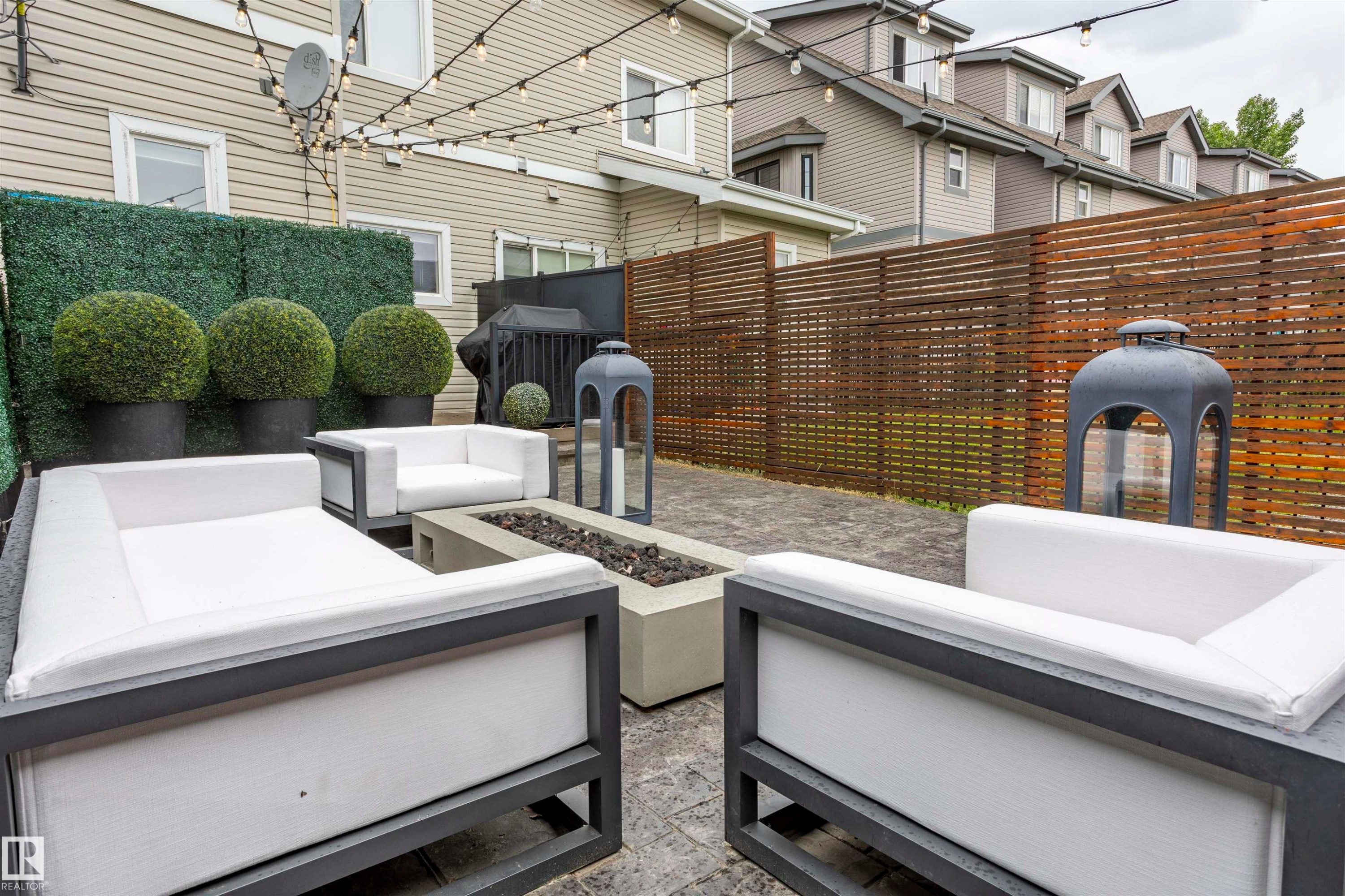 Hardscaped patio with paver flooring, a built-in fire pit, and slatted wood privacy fencing - 4949 Terwillegar Common Nw, Edmonton, AB