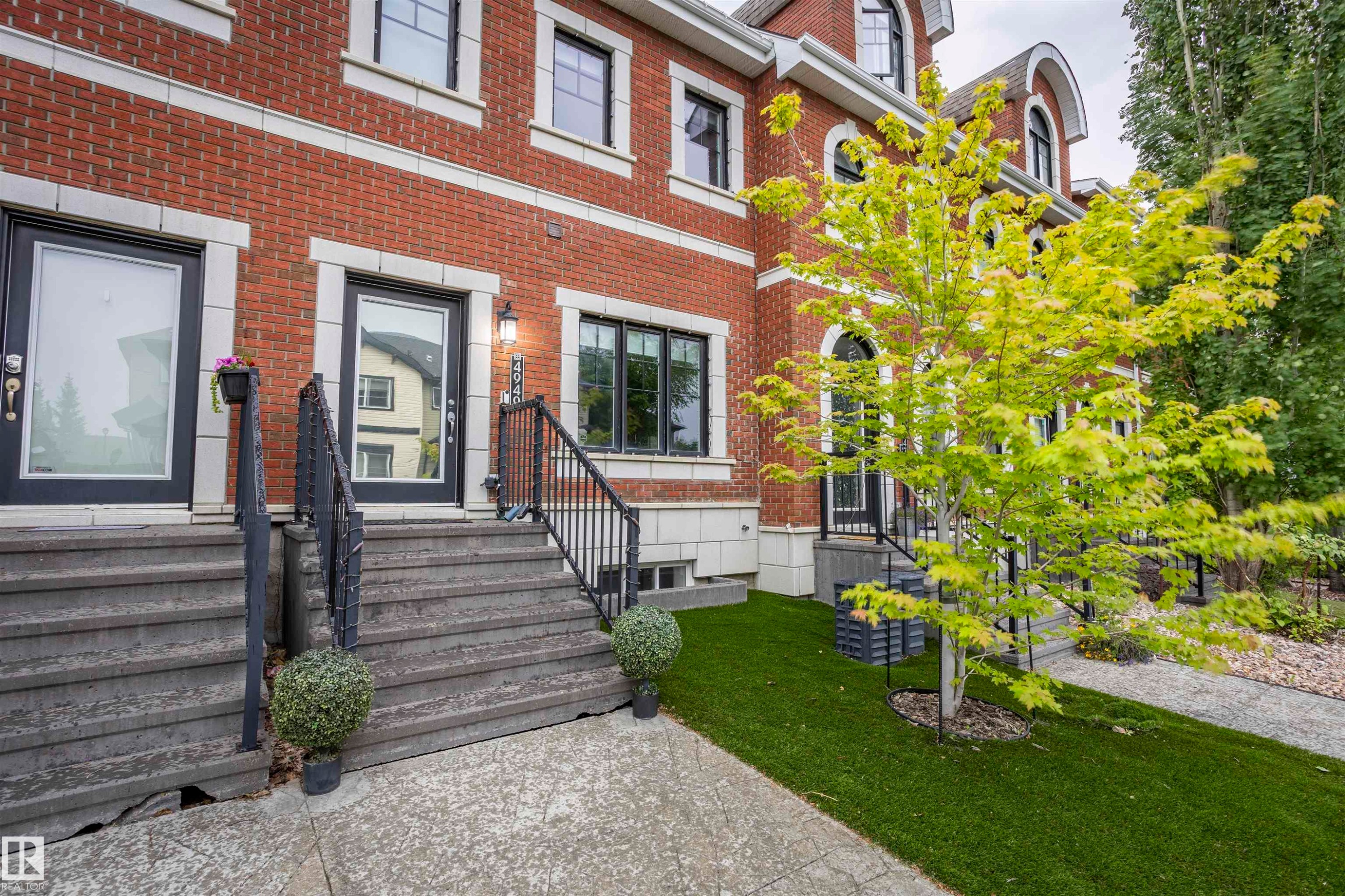 Brick facade residence with a stone entry staircase and black metal handrails - 4949 Terwillegar Common Nw, Edmonton, AB