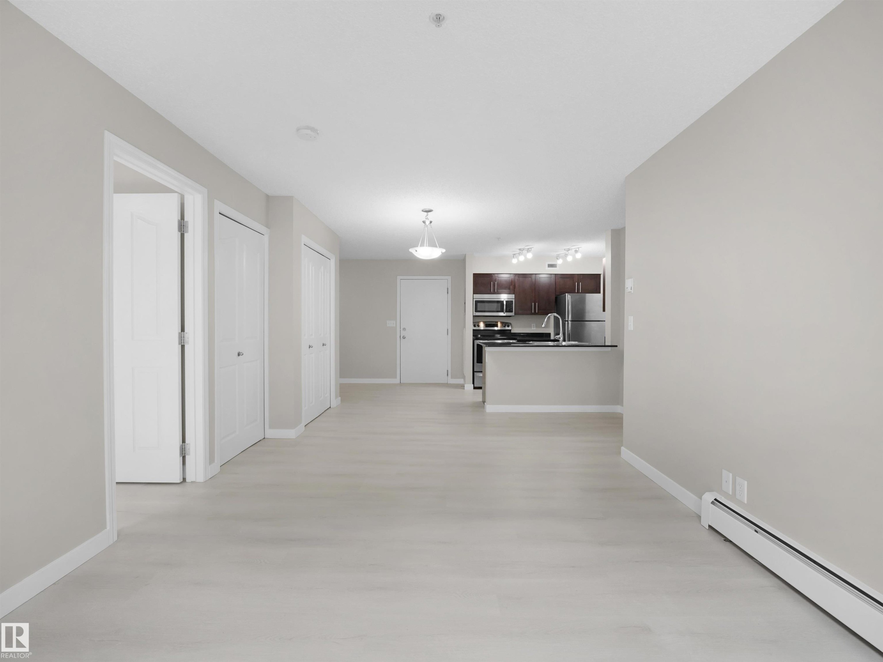 Open concept living space with light wood-finish flooring - 220 12035 22 Avenue, Edmonton, AB