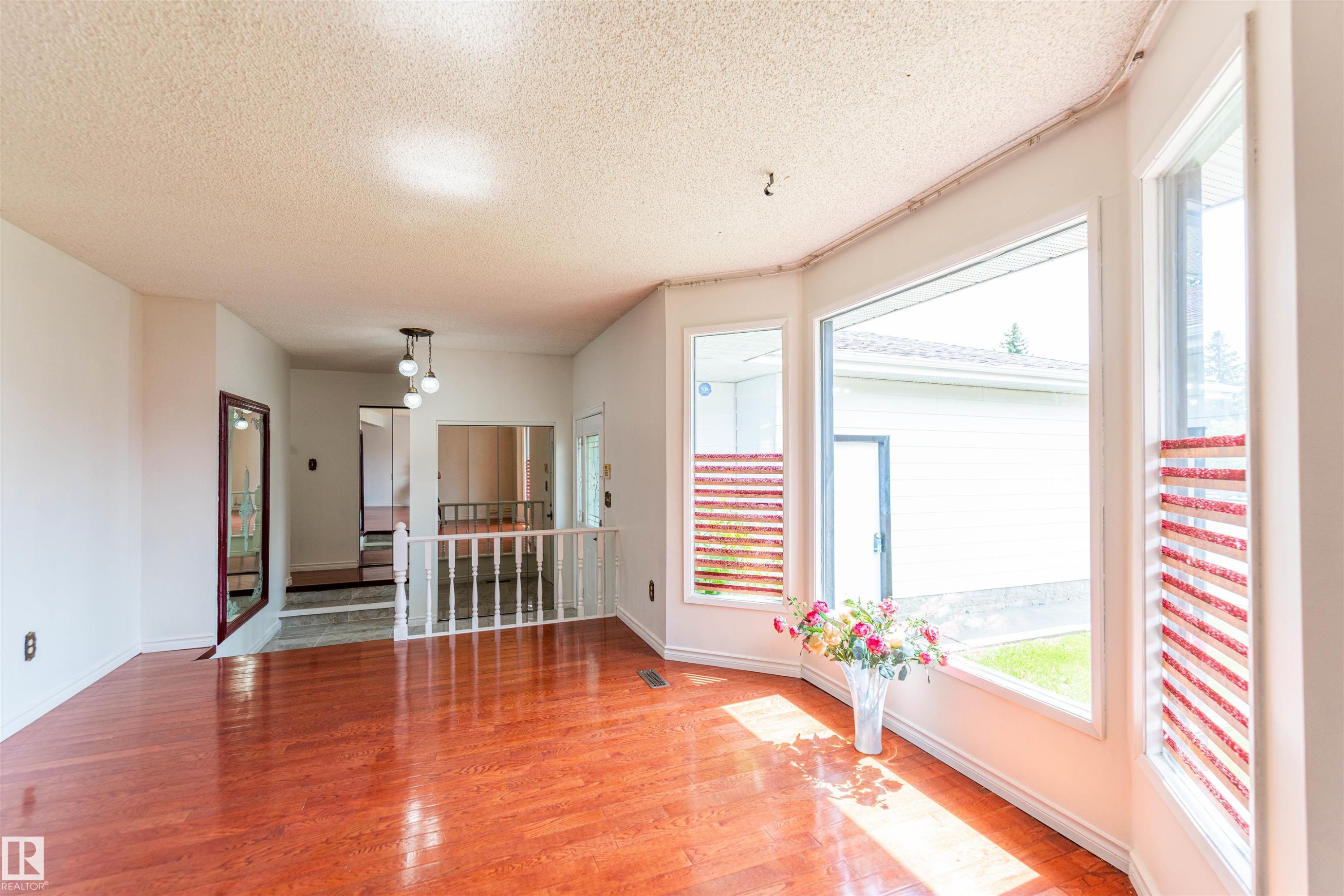 Hardwood-finish flooring throughout the main living area, complemented by a large bay window - 16524 116 Street, Edmonton, AB