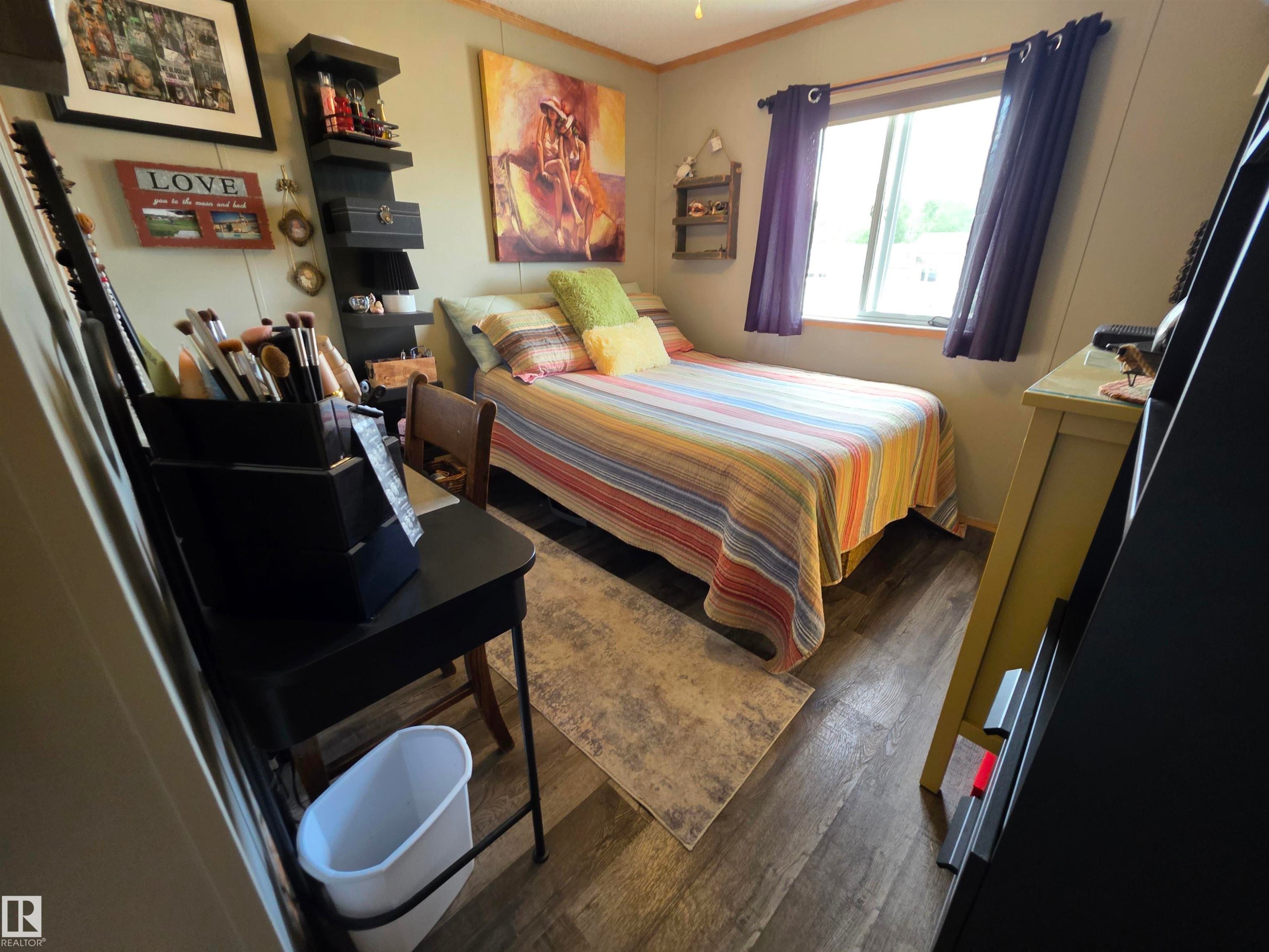 Compact room featuring wood-finish flooring, a single window with curtains, and a built-in wall shelf - 88B 3400 48 Street, Stony Plain, AB
