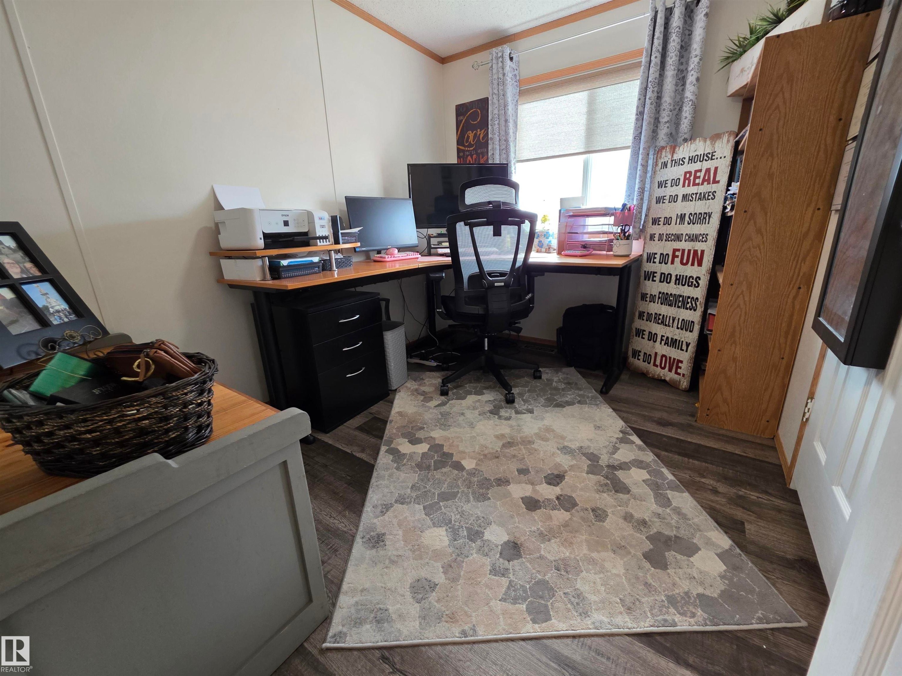 Dedicated office space featuring wood-finish flooring, a corner desk, and a window with blinds - 88B 3400 48 Street, Stony Plain, AB