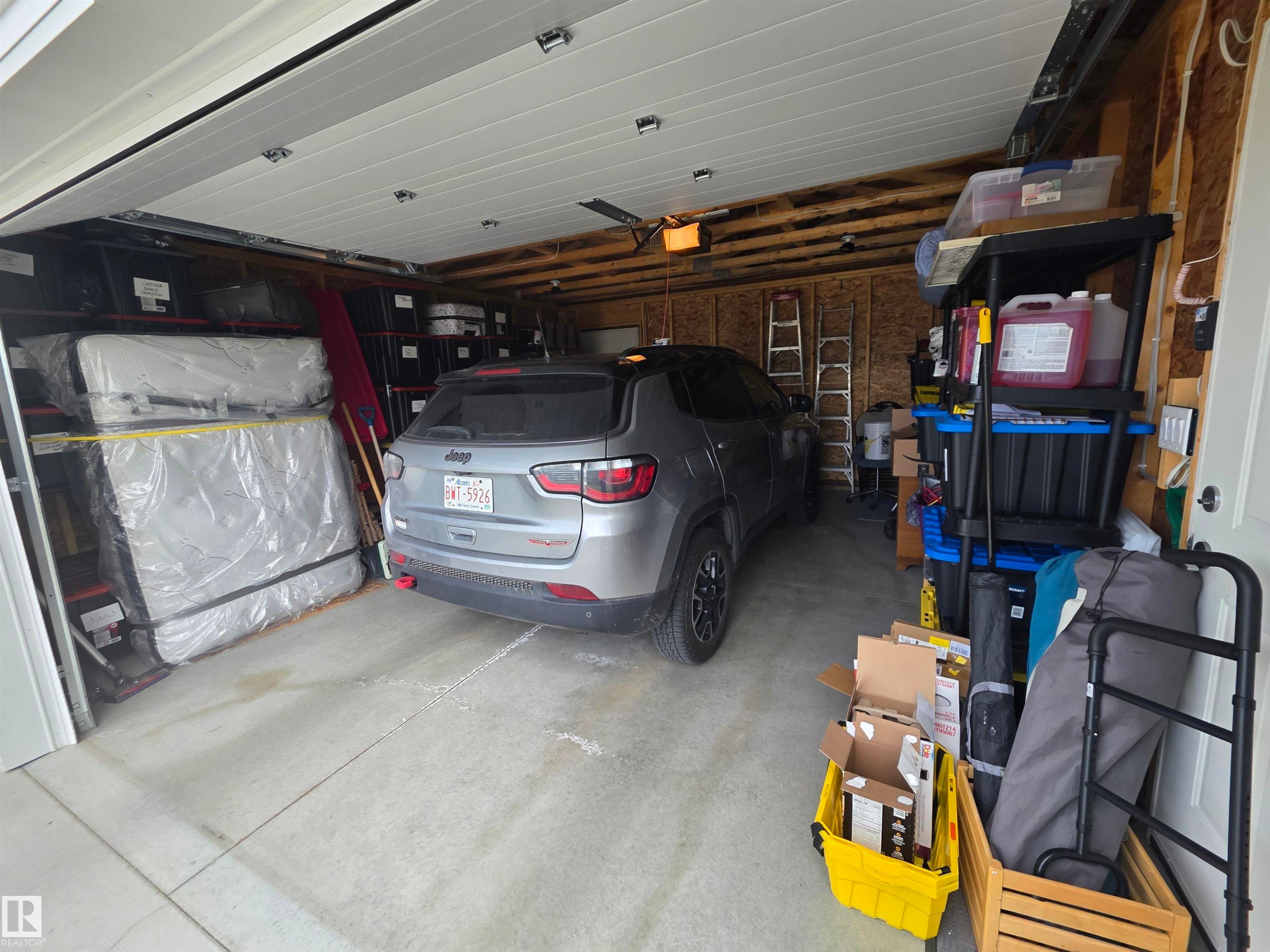Attached two-car garage featuring a concrete floor and overhead garage door - 88B 3400 48 Street, Stony Plain, AB