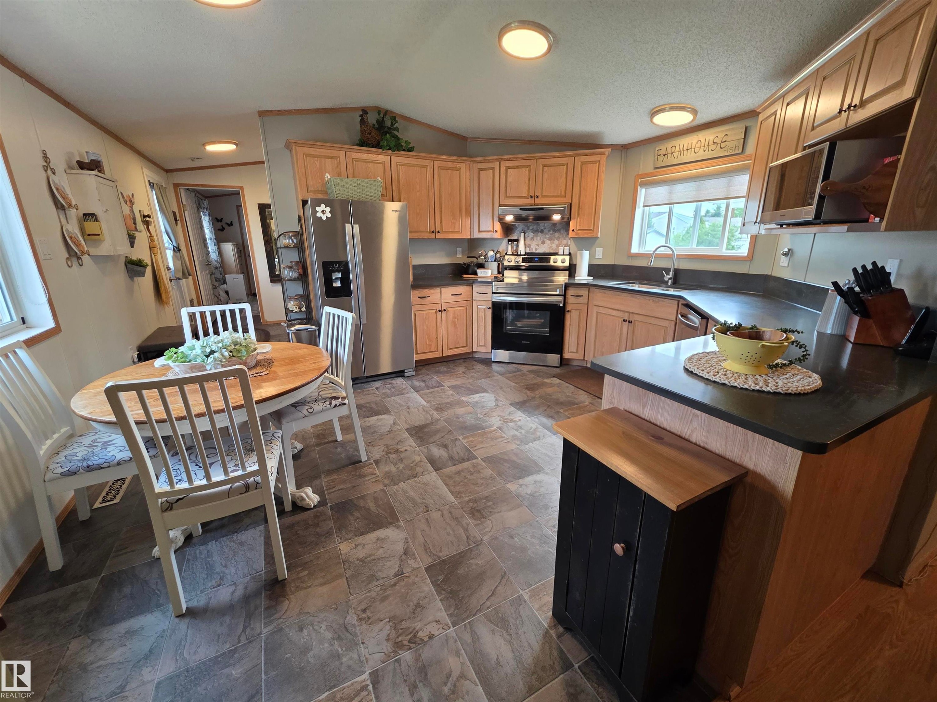 Kitchen featuring light wood cabinetry, stone-look tile flooring, and a stainless steel appliance suite - 88B 3400 48 Street, Stony Plain, AB