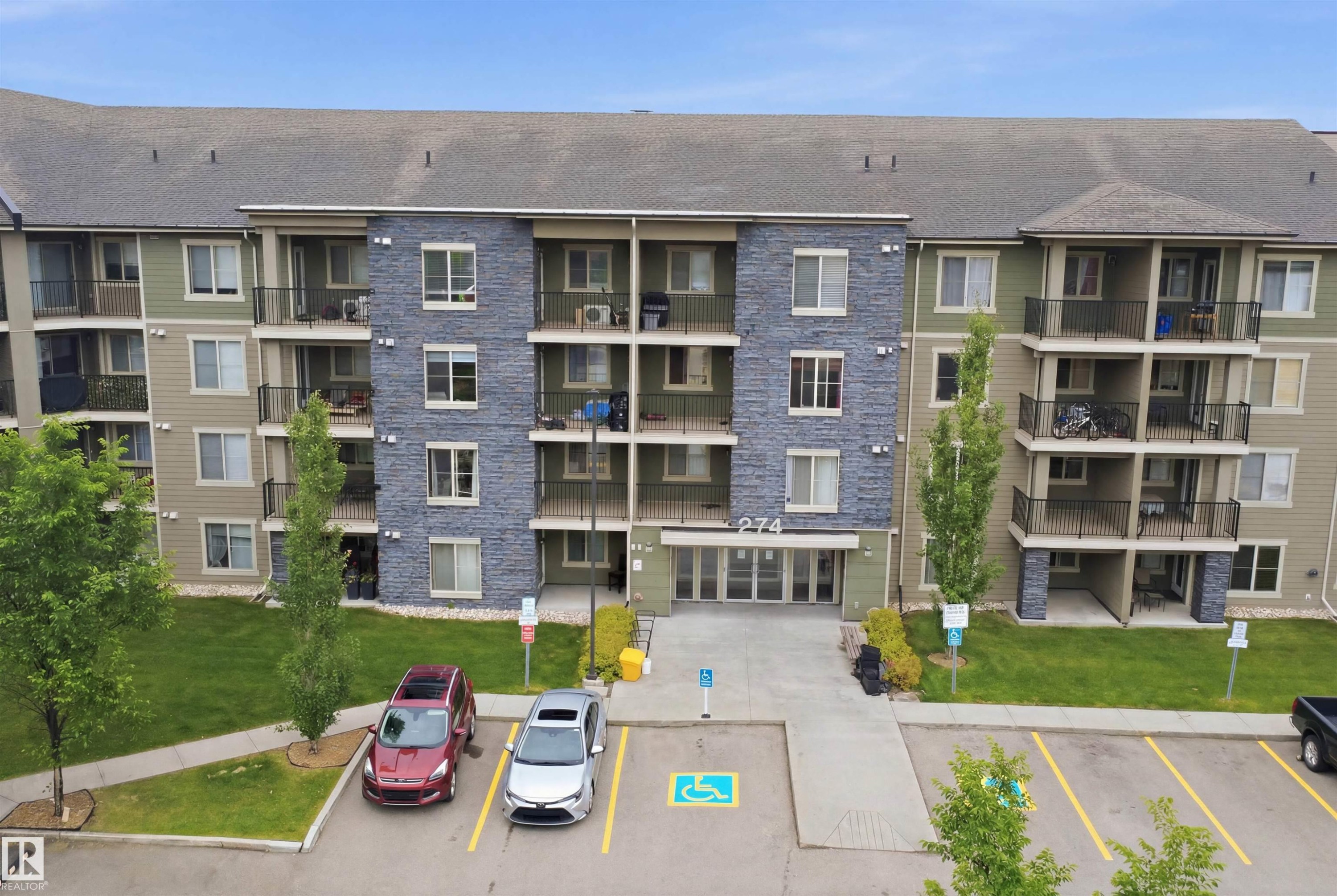 Multi-story building featuring a stone facade and multiple balconies - 115 274 Mcconachie Drive, Edmonton, AB