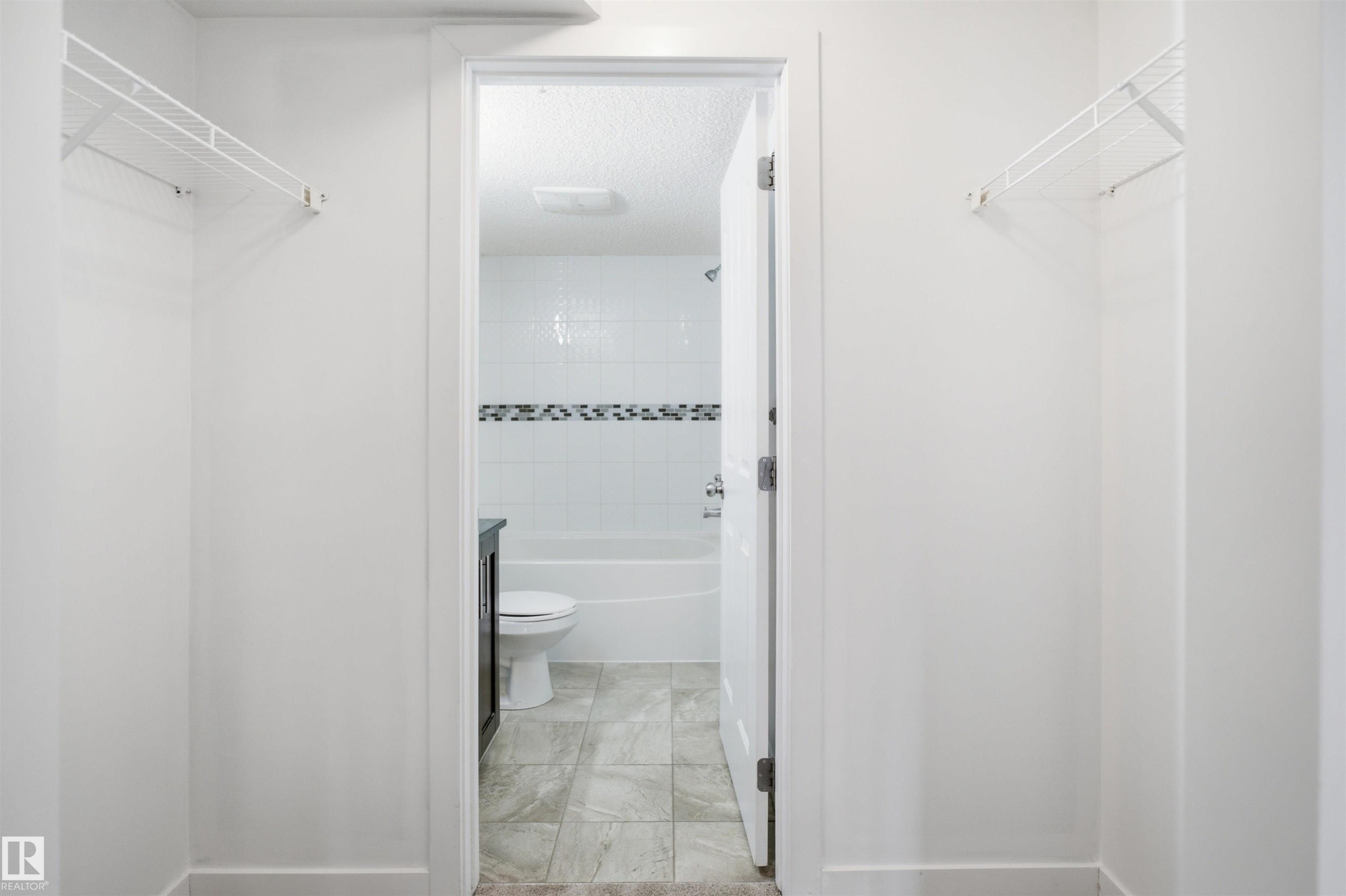 Walk-through closet featuring white wire shelving - 115 274 Mcconachie Drive, Edmonton, AB
