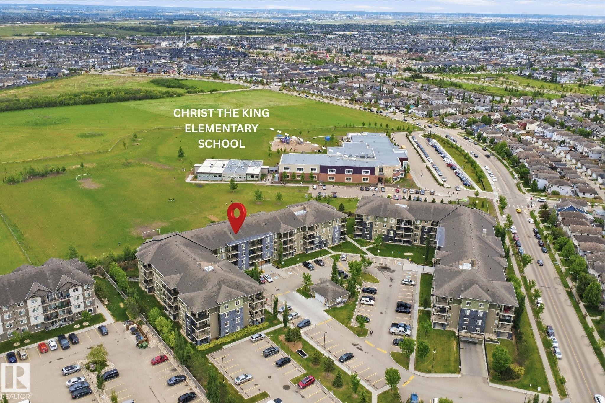 Residential complex featuring multiple multi-story buildings with balconies, surface parking, and green spaces - 115 274 Mcconachie Drive, Edmonton, AB
