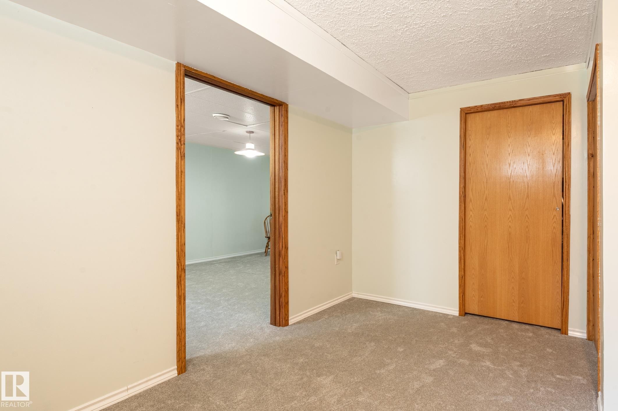 Carpeted area with light-toned walls and wood-finish trim - 14708 108 Av, Edmonton, AB