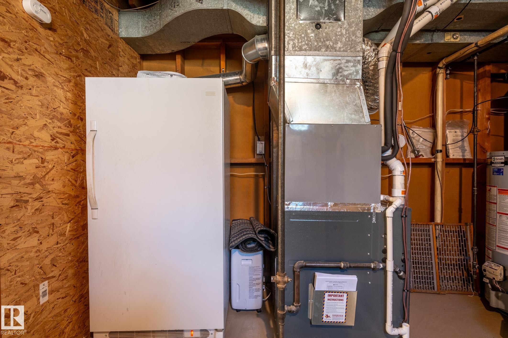 Utility space featuring a forced-air furnace with visible ductwork, a water heater, and a water softener - 14708 108 Av, Edmonton, AB