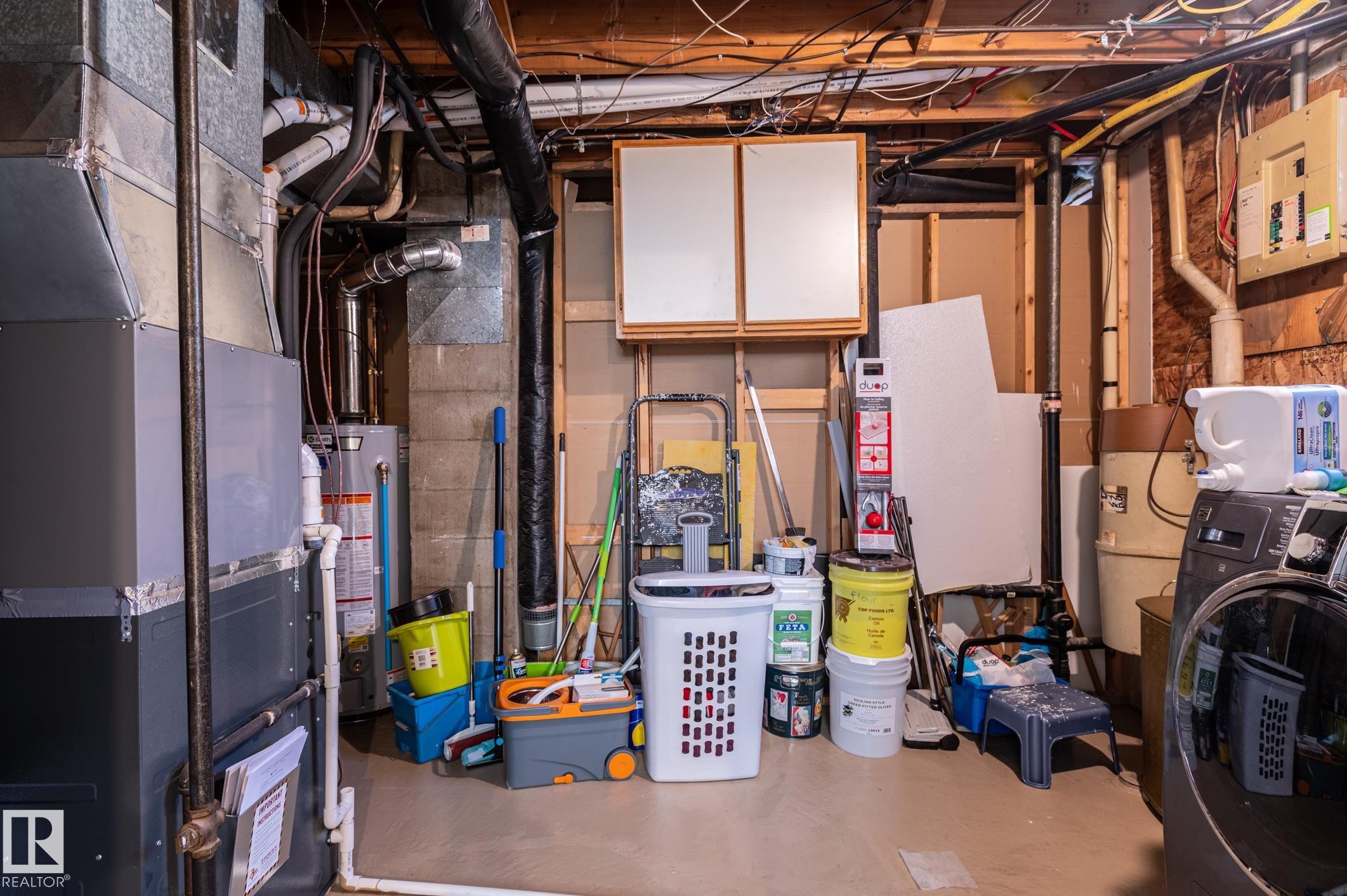 Utility space featuring a furnace, water heater, exposed ductwork, and electrical paneling - 14708 108 Av, Edmonton, AB