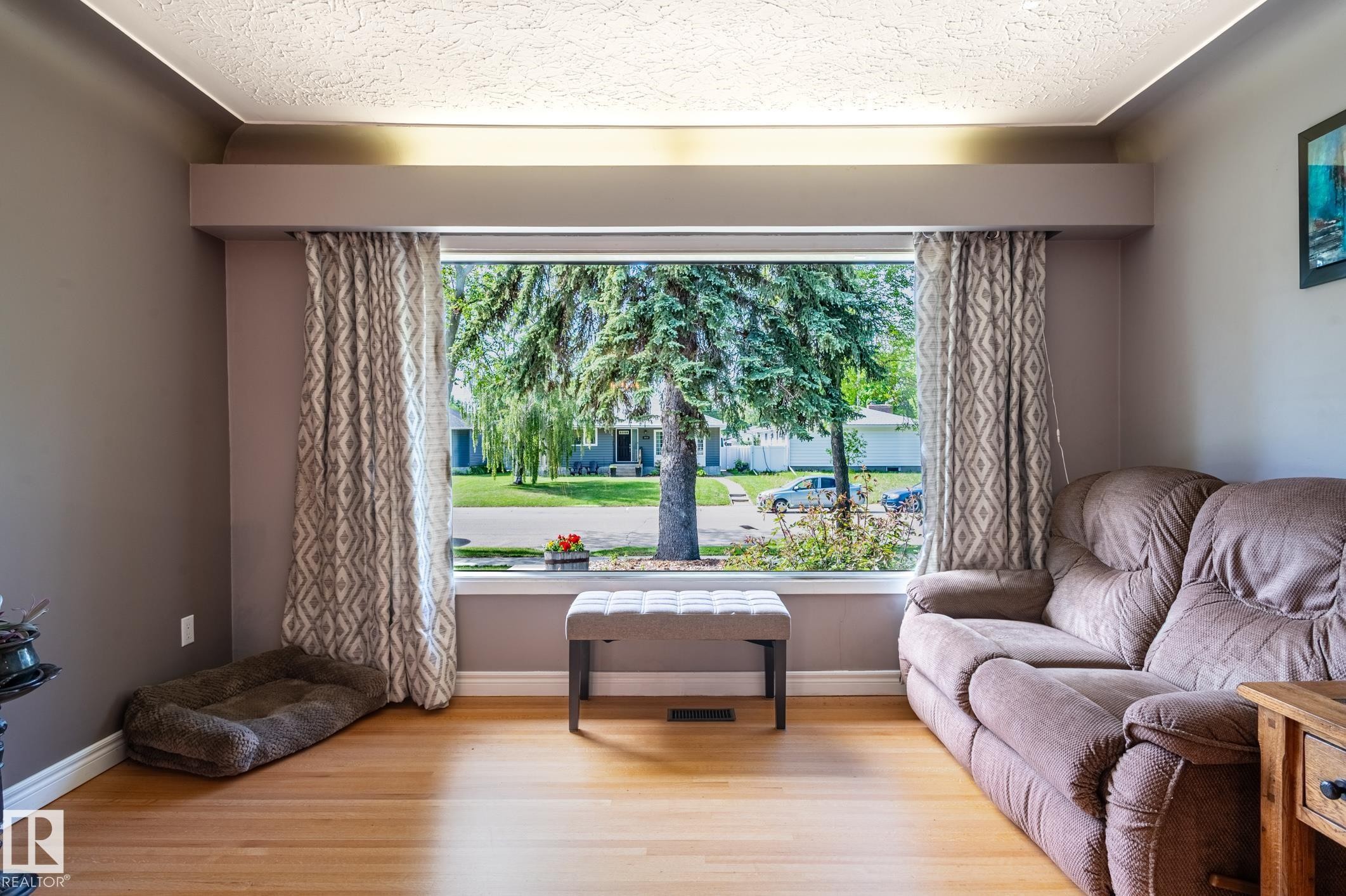 Hardwood flooring complemented by a large picture window, crown molding, and recessed lighting - 14708 108 Av, Edmonton, AB