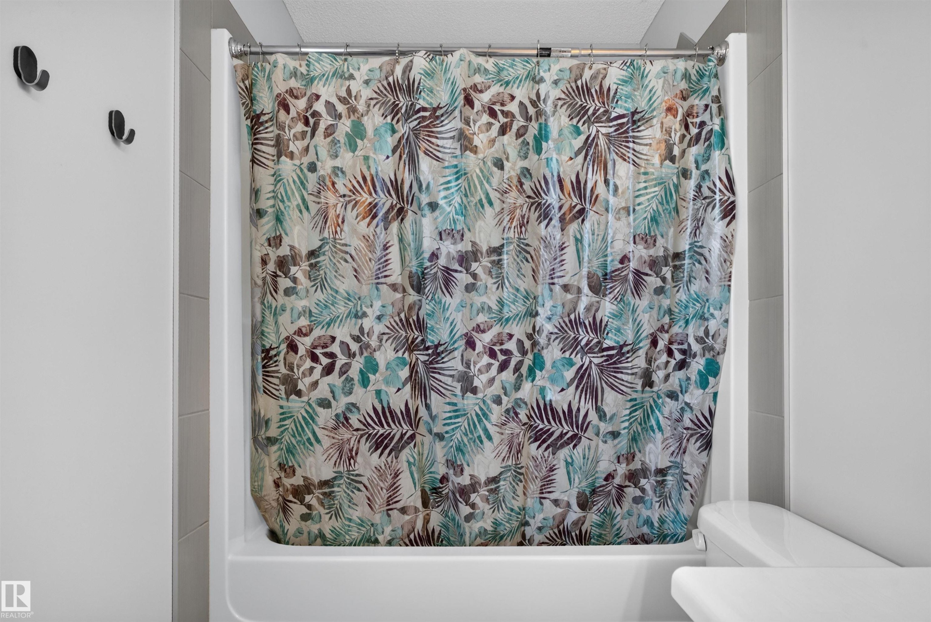 White shower/tub combination with a chrome curtain rod - 4612 Westcliff Point(E), Edmonton, AB