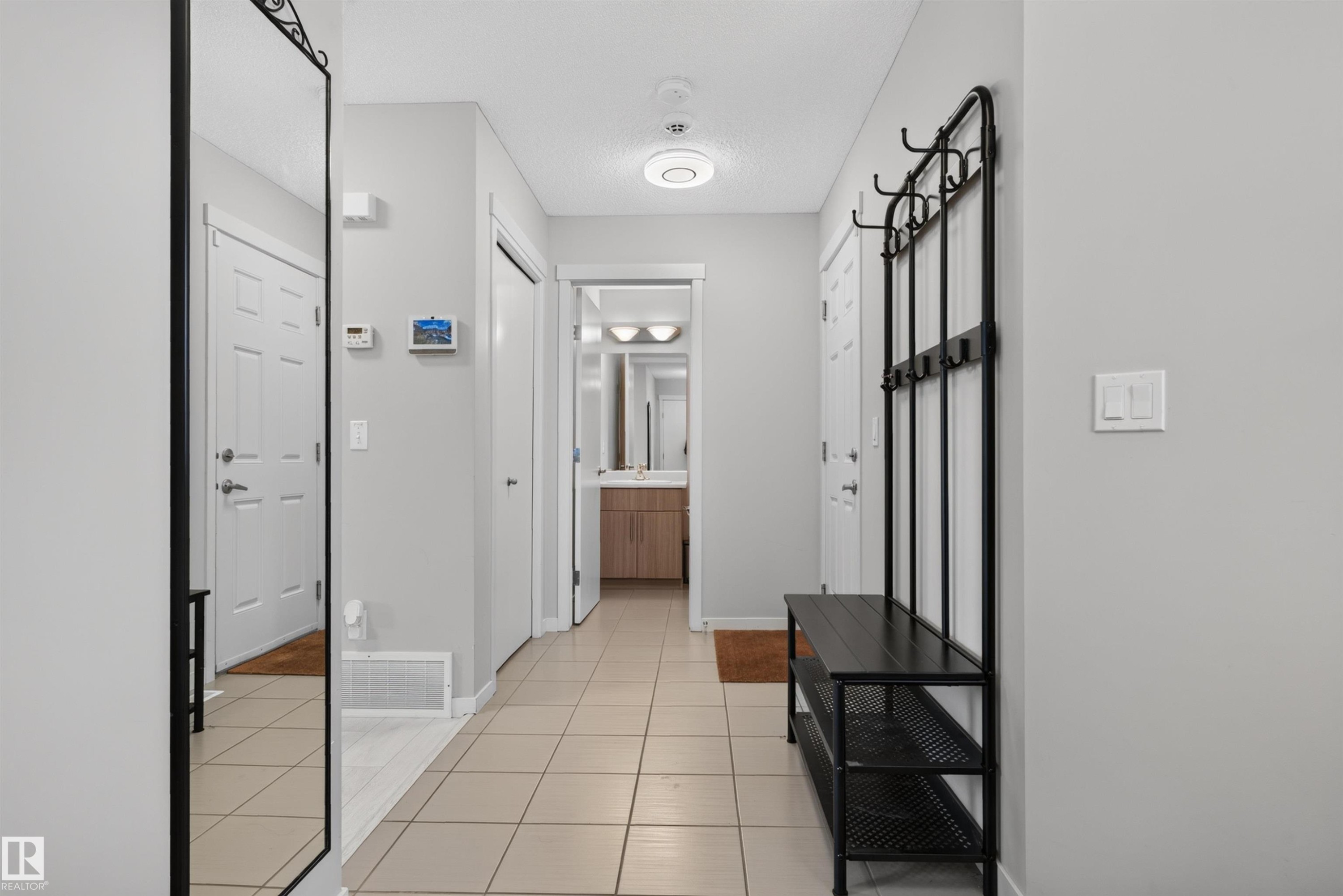 Bright entryway featuring light neutral wall paint and square tile flooring - 4612 Westcliff Point(E), Edmonton, AB