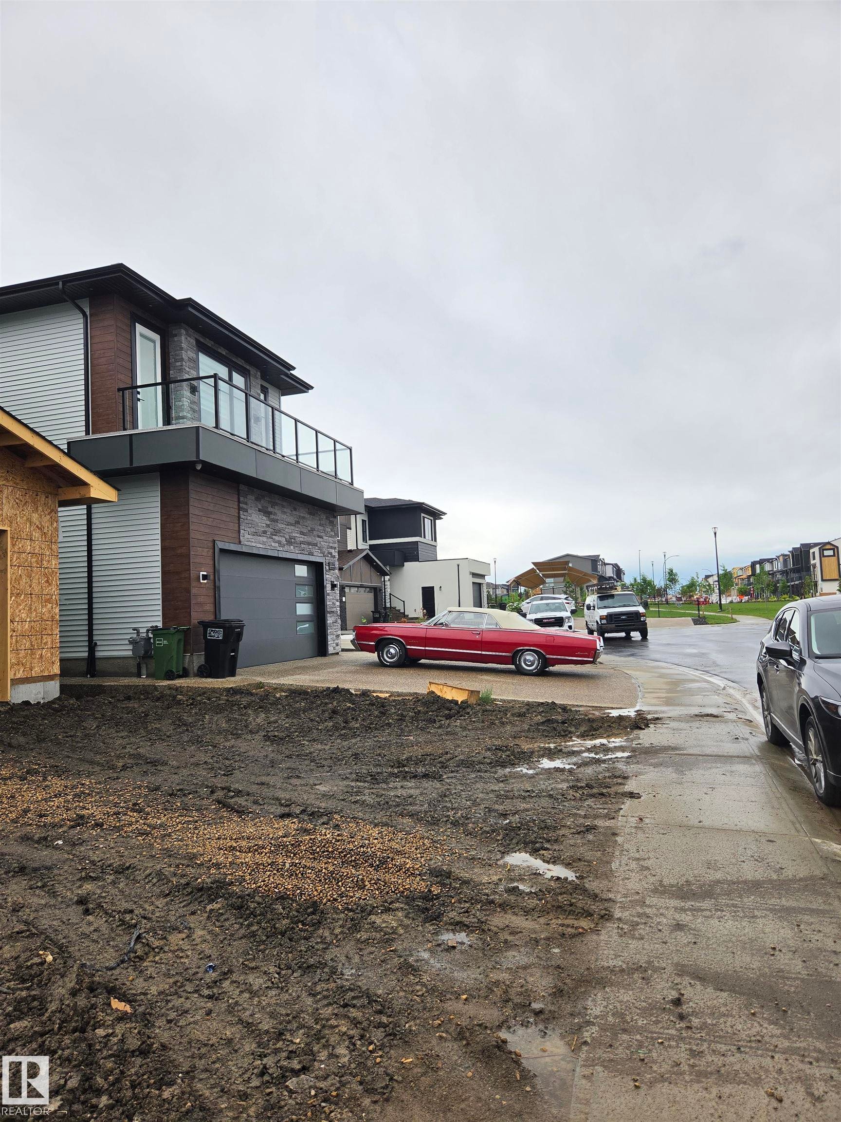 Contemporary exterior featuring horizontal siding, stone cladding, and a second-story balcony with glass railings - 113 29A Street, Edmonton, AB