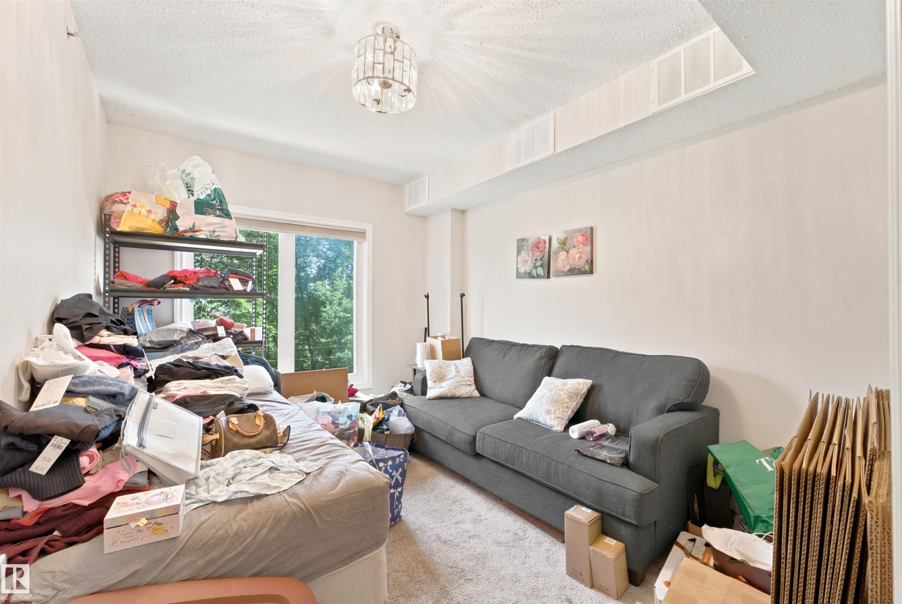 Recessed window framing exterior greenery, with a contemporary ceiling light fixture - 305 11111 82 Avenue, Edmonton, AB