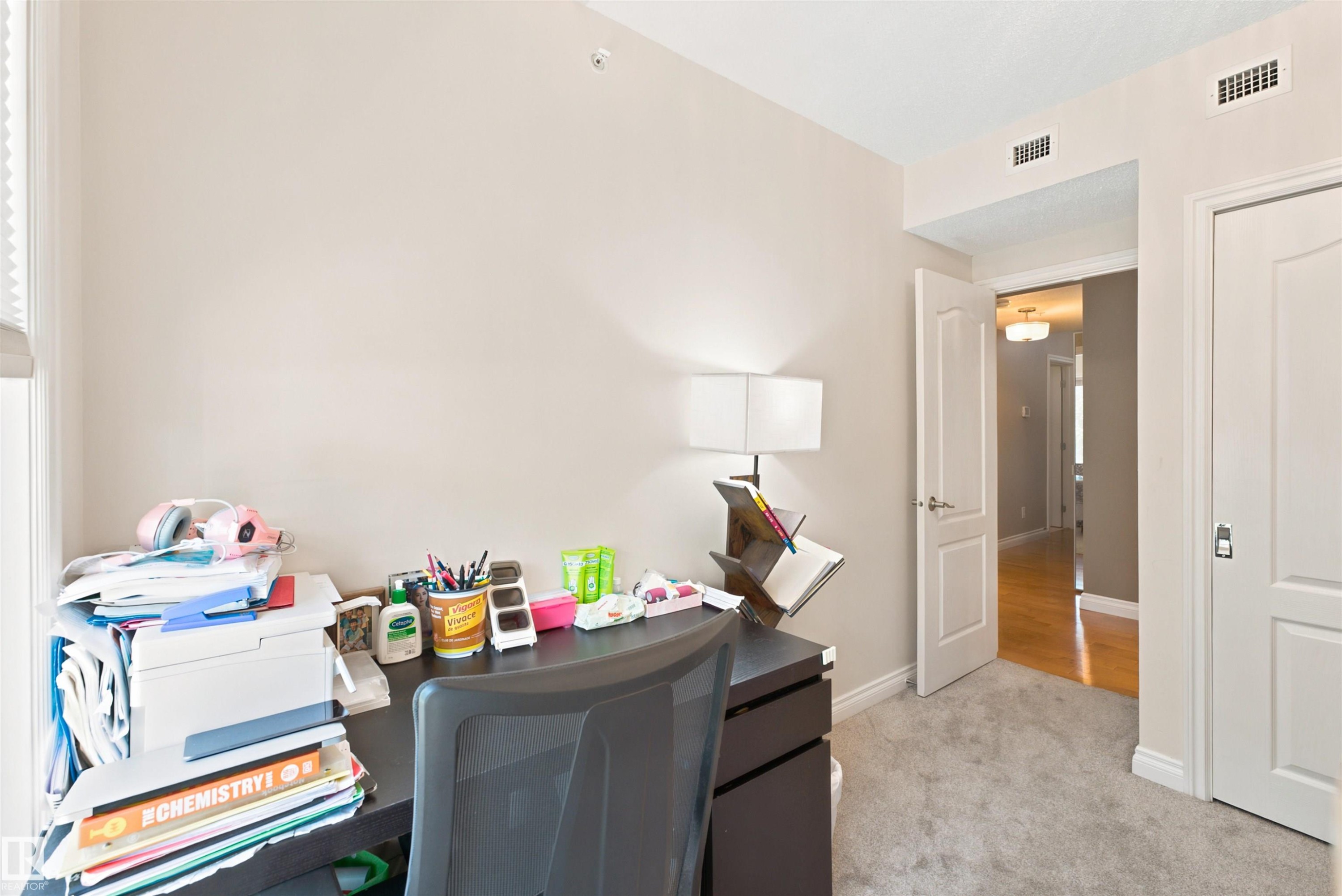 Carpeted room with light neutral wall paint and white trim, featuring a window with a roller shade - 305 11111 82 Avenue, Edmonton, AB