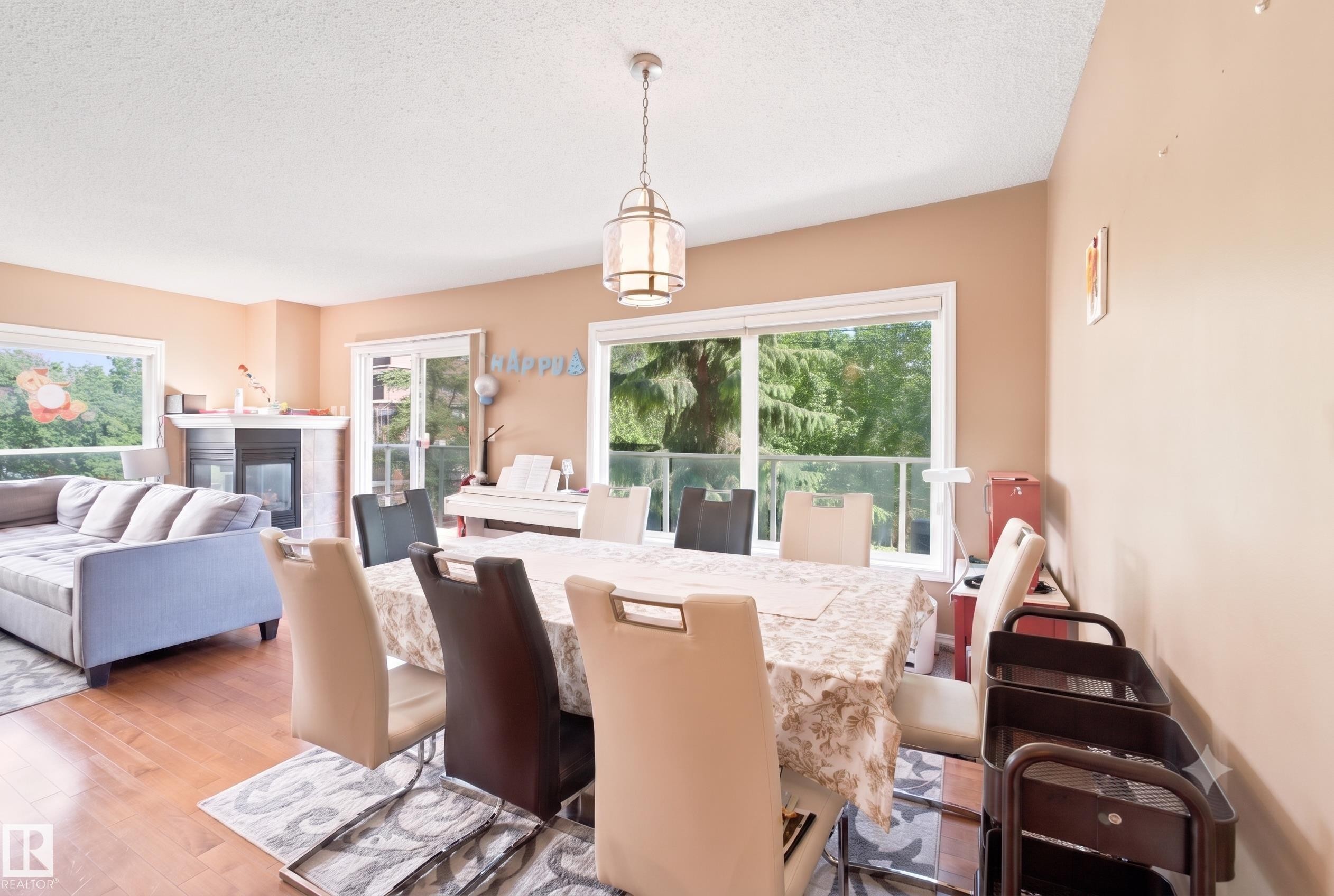 Spacious dining area featuring wood-finish flooring and a contemporary pendant light fixture - 305 11111 82 Avenue, Edmonton, AB