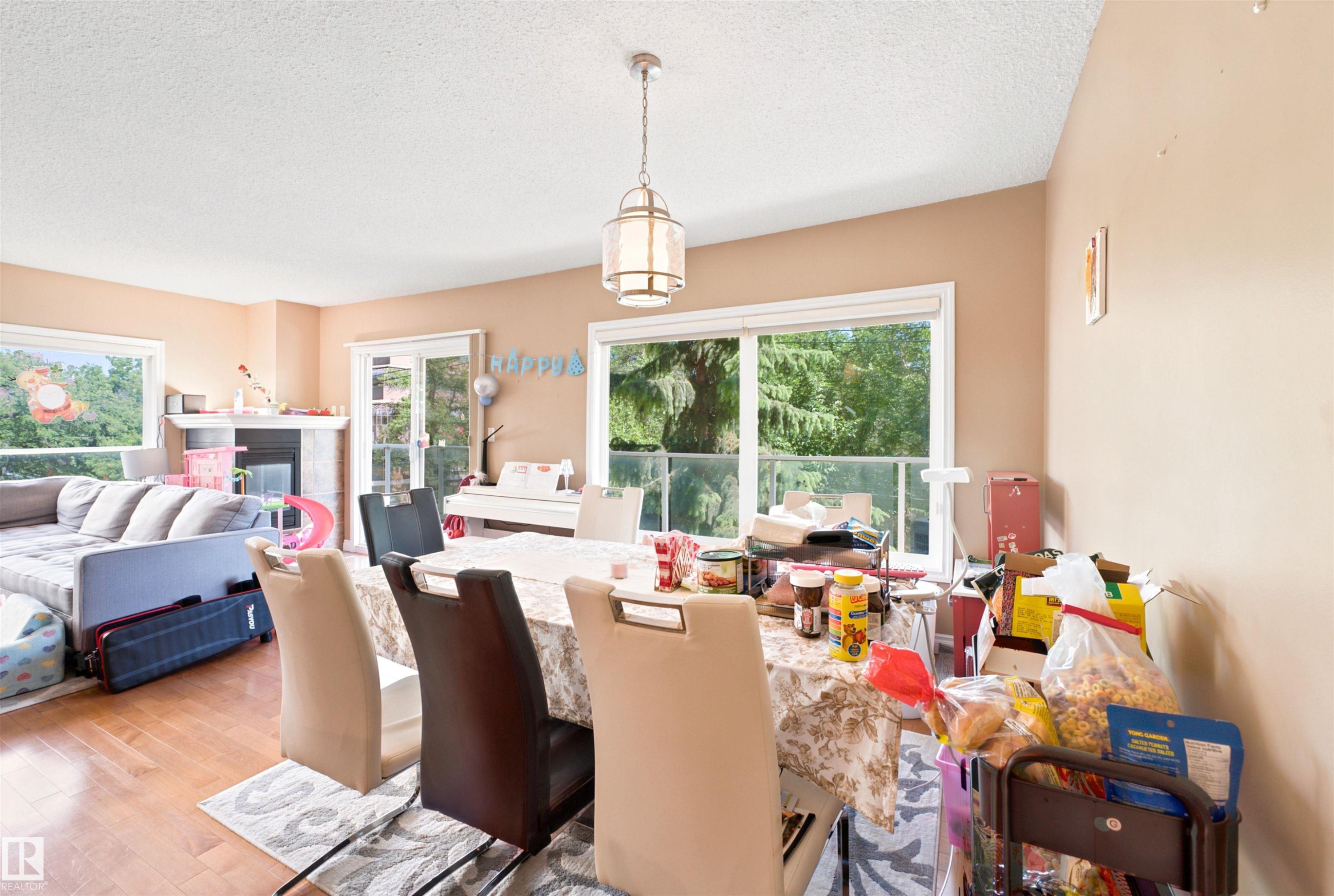 Bright dining area featuring a contemporary chandelier and wood-finish flooring - 305 11111 82 Avenue, Edmonton, AB