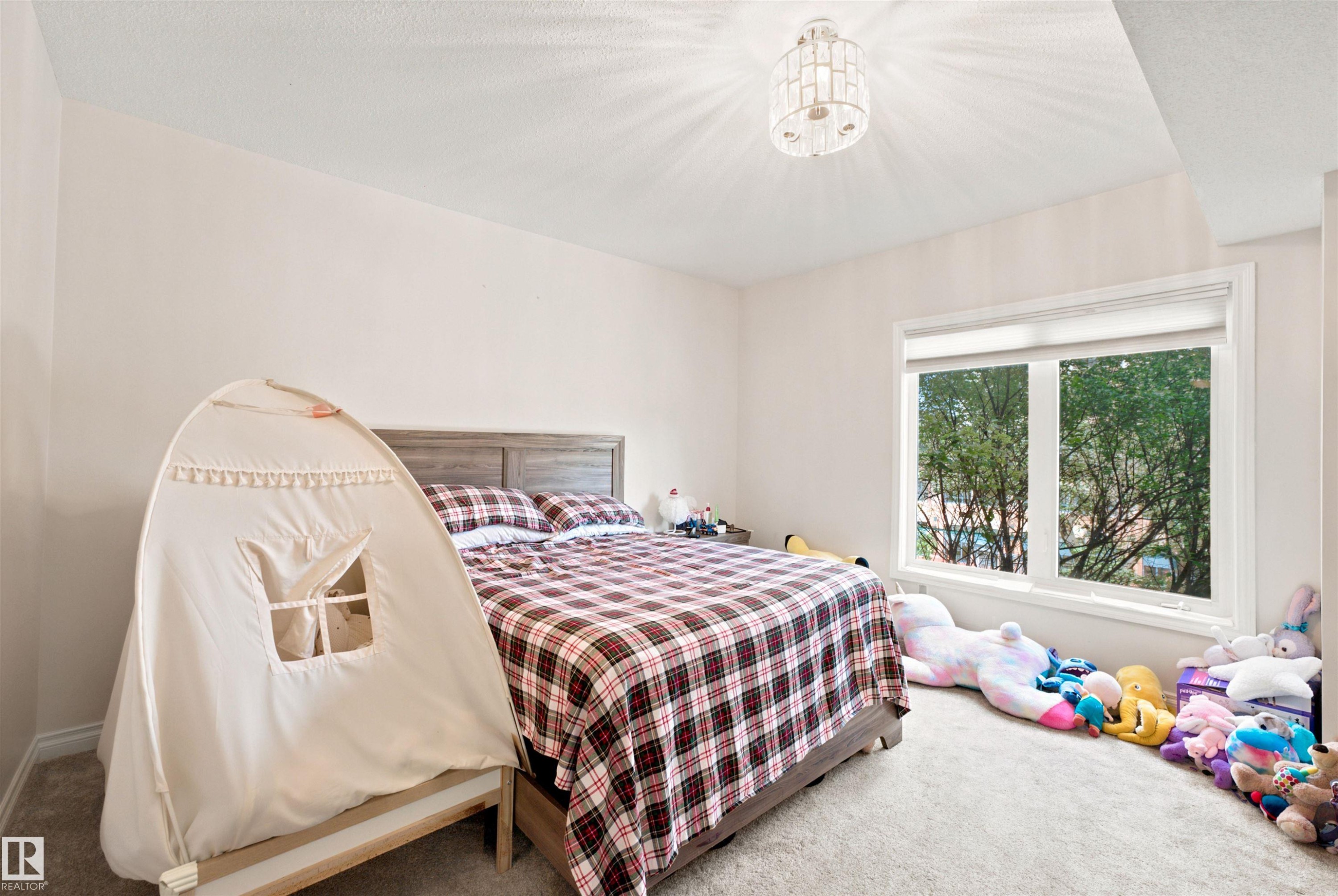 Bedroom featuring neutral wall paint, light gray carpet, and a large window with white trim - 305 11111 82 Avenue, Edmonton, AB