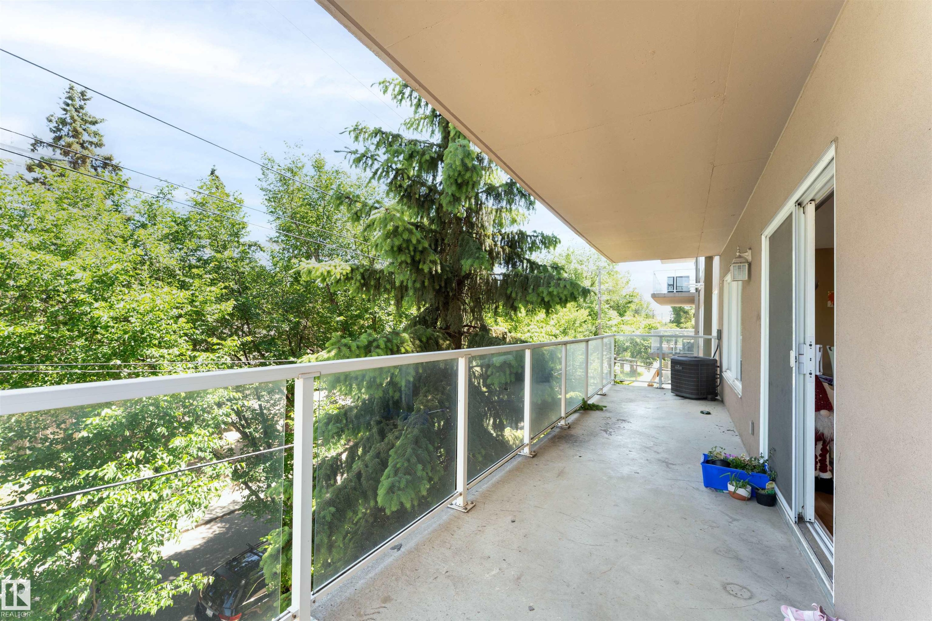 Expansive balcony featuring a concrete surface, glass panel railing, and a covered ceiling - 305 11111 82 Avenue, Edmonton, AB