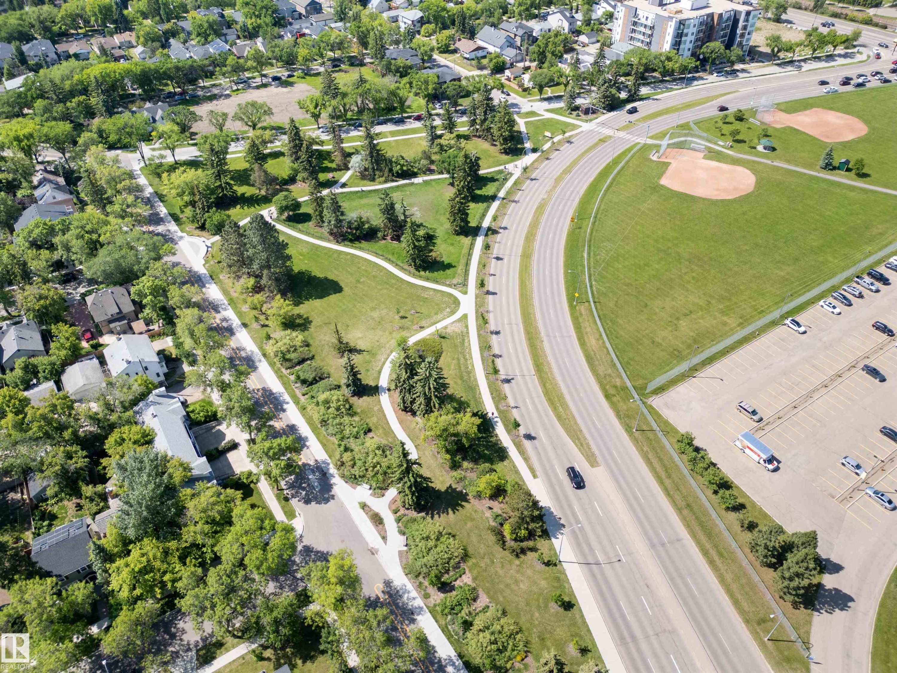 Aerial perspective showcasing residential properties, expansive green spaces, and a multi-lane roadway - 305 11111 82 Avenue, Edmonton, AB
