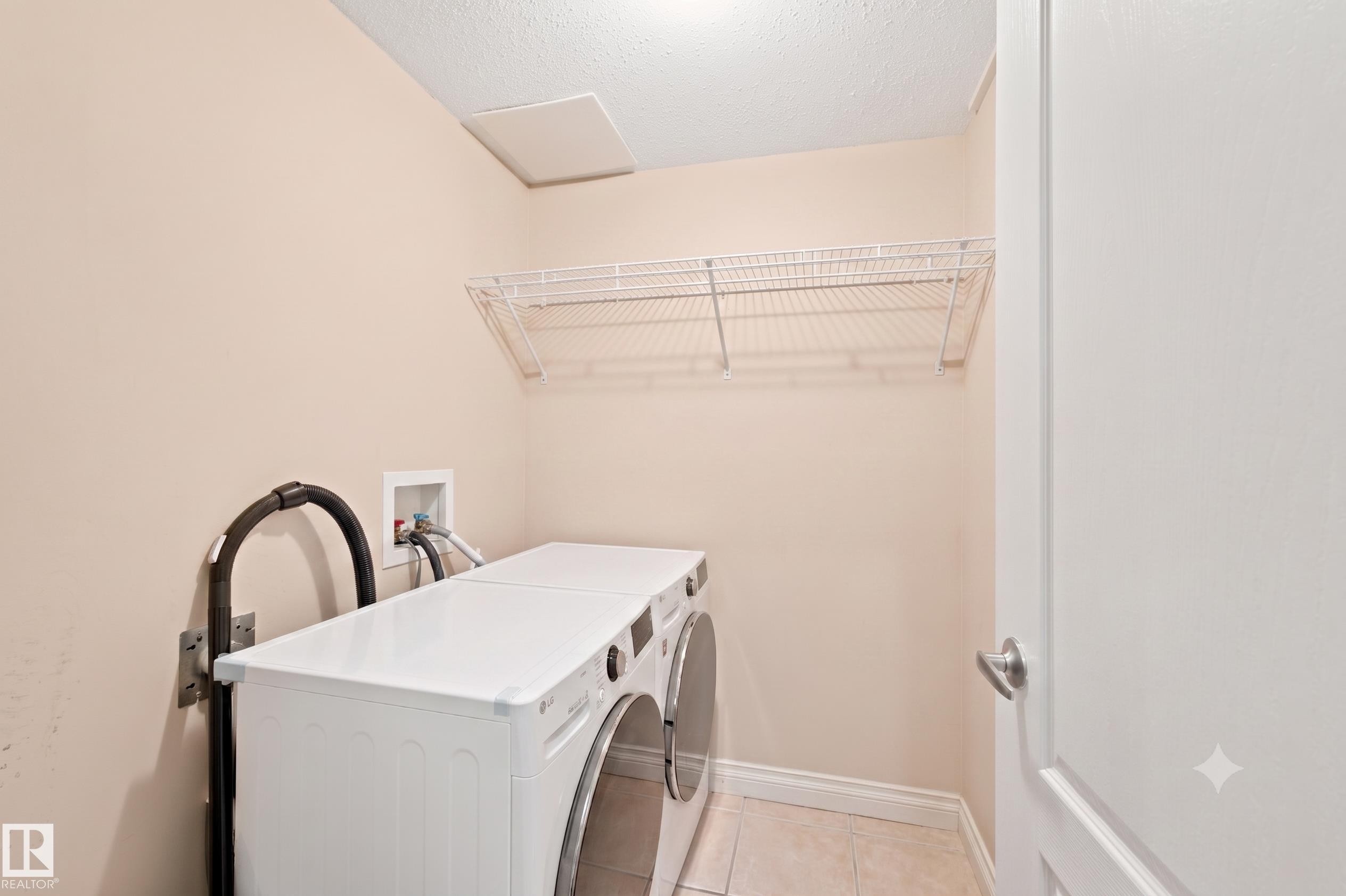 Dedicated utility room featuring light-colored walls, tile flooring, and a white wire shelving unit for storage - 305 11111 82 Avenue, Edmonton, AB