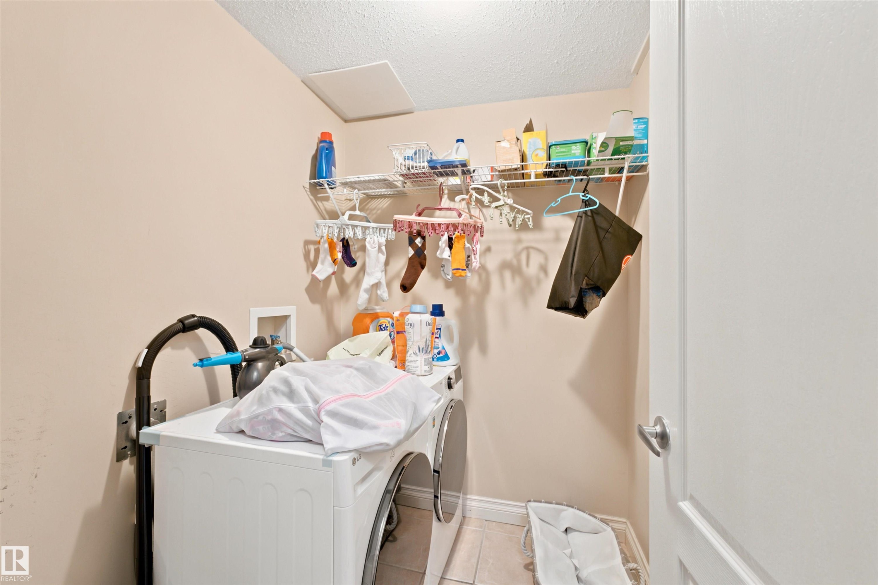 Dedicated laundry area featuring a washer and dryer unit, wire shelving, and neutral wall paint - 305 11111 82 Avenue, Edmonton, AB