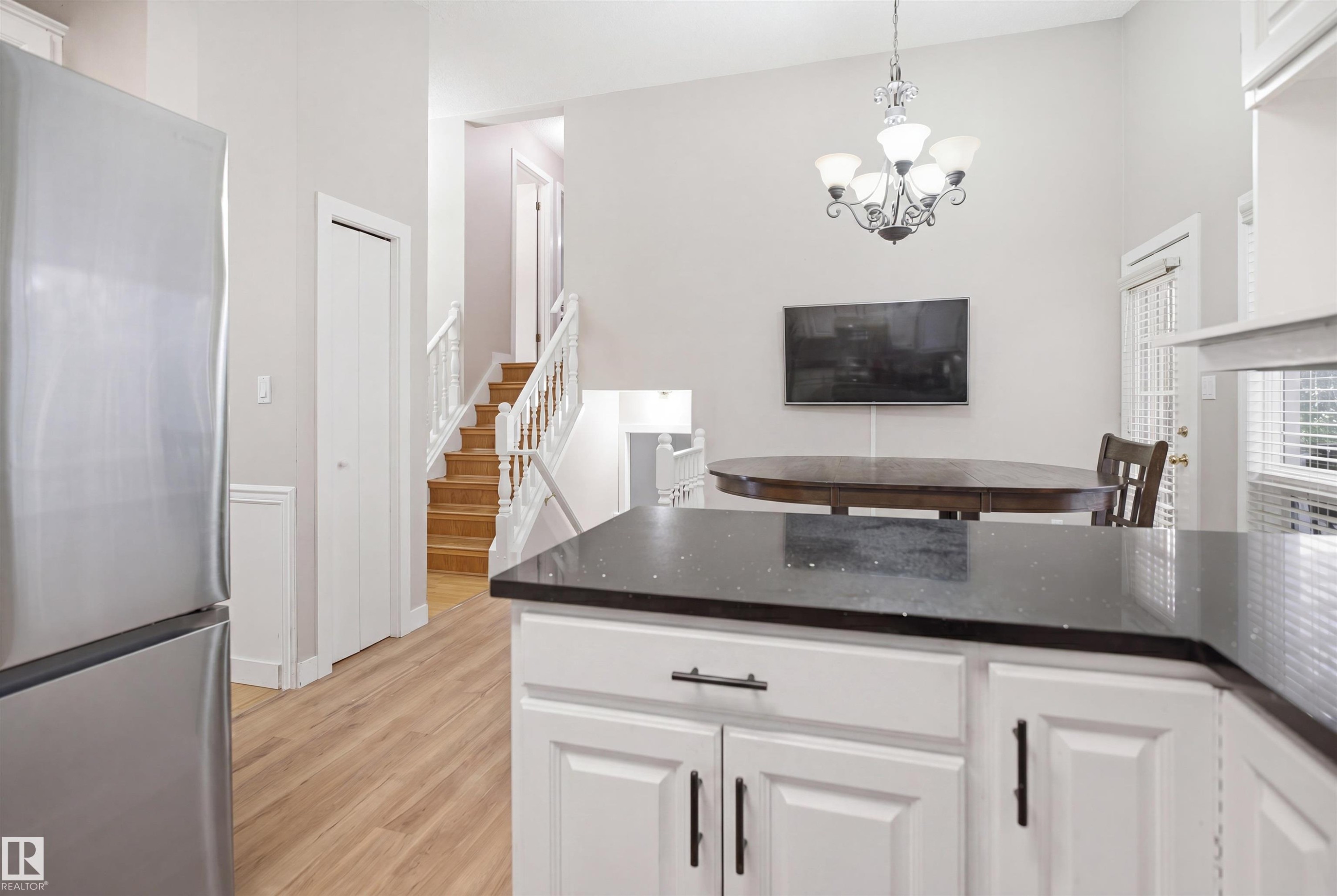 Kitchen counter featuring dark speckled countertop, white cabinetry, and matte black hardware - 3220 42A Avenue, Edmonton, AB