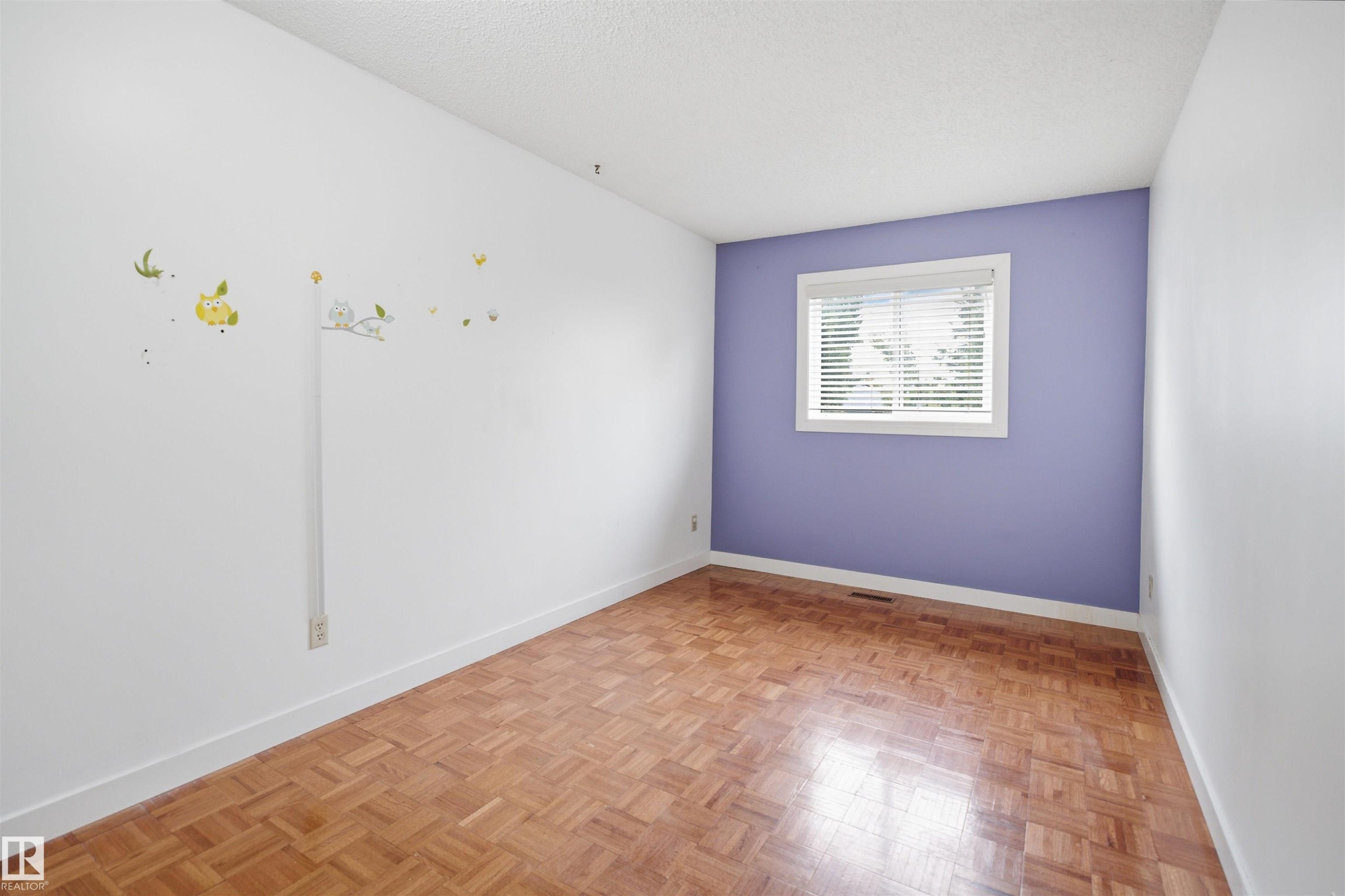 Room featuring parquet wood flooring, white baseboards, and a window with white blinds - 3220 42A Avenue, Edmonton, AB