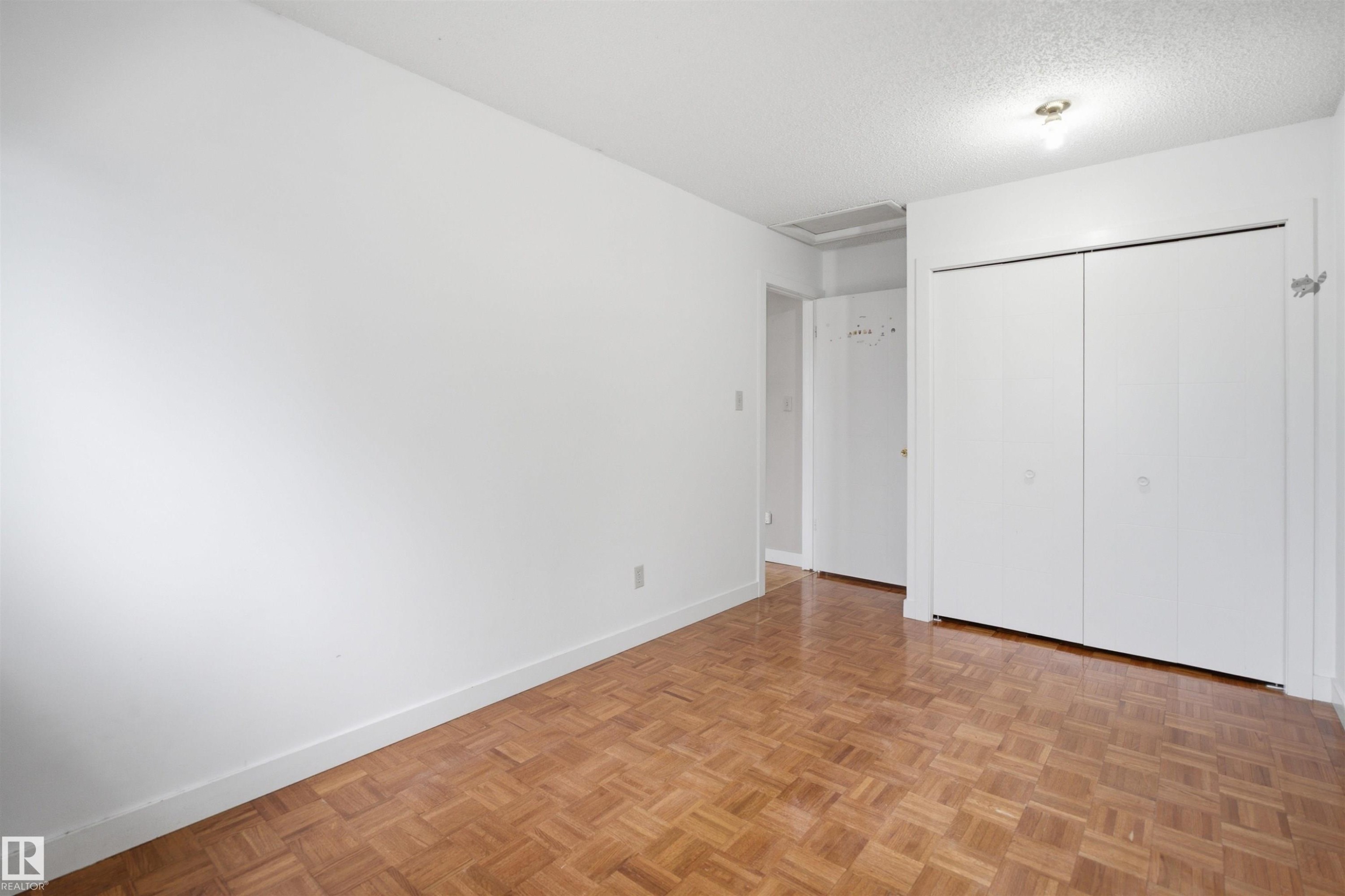 Room featuring parquet wood flooring and white baseboards - 3220 42A Avenue, Edmonton, AB