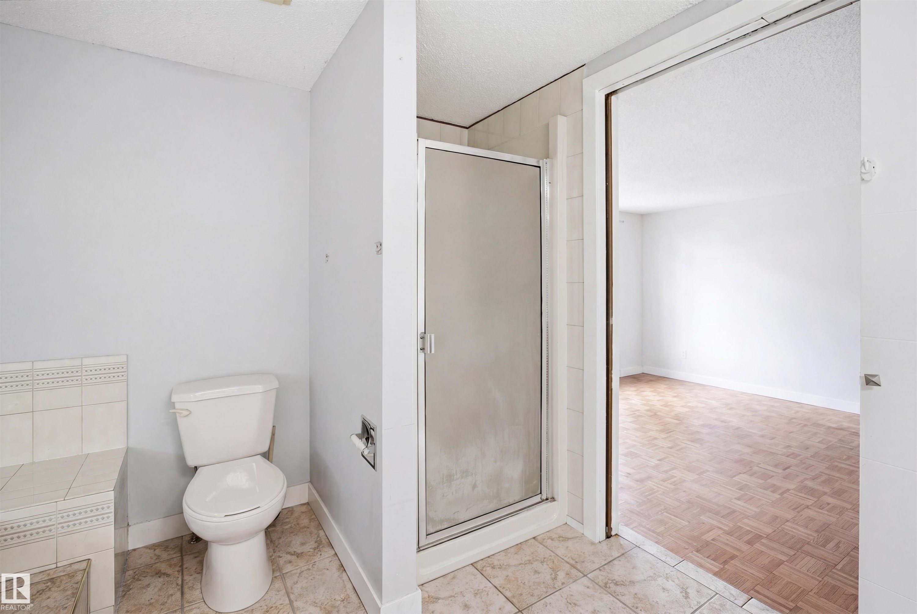 Bathroom featuring a glass-enclosed shower, tiled flooring, and a white toilet - 3220 42A Avenue, Edmonton, AB
