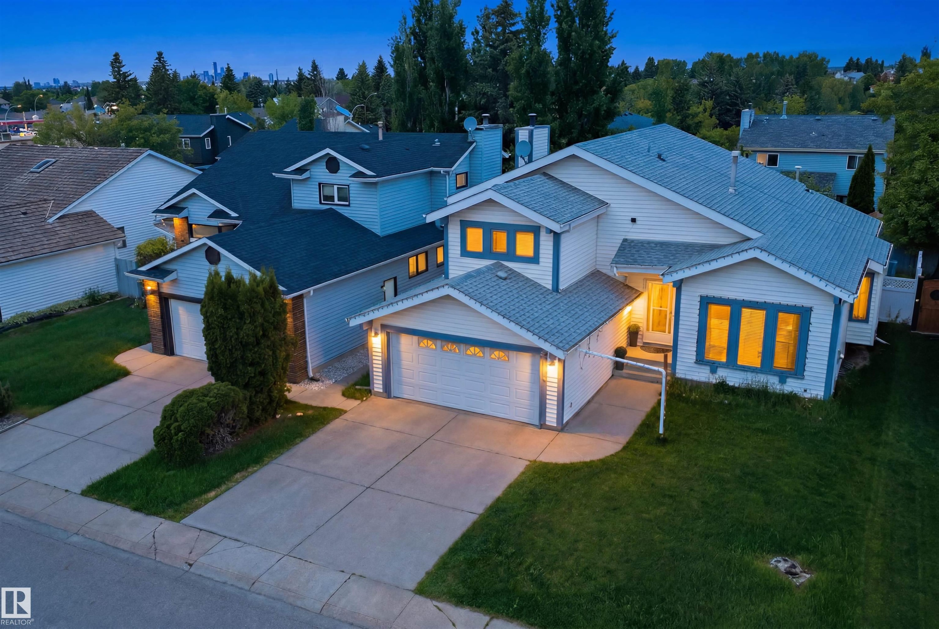 Two-story residence featuring white siding with blue trim accents and a multi-pitched roof - 3220 42A Avenue, Edmonton, AB