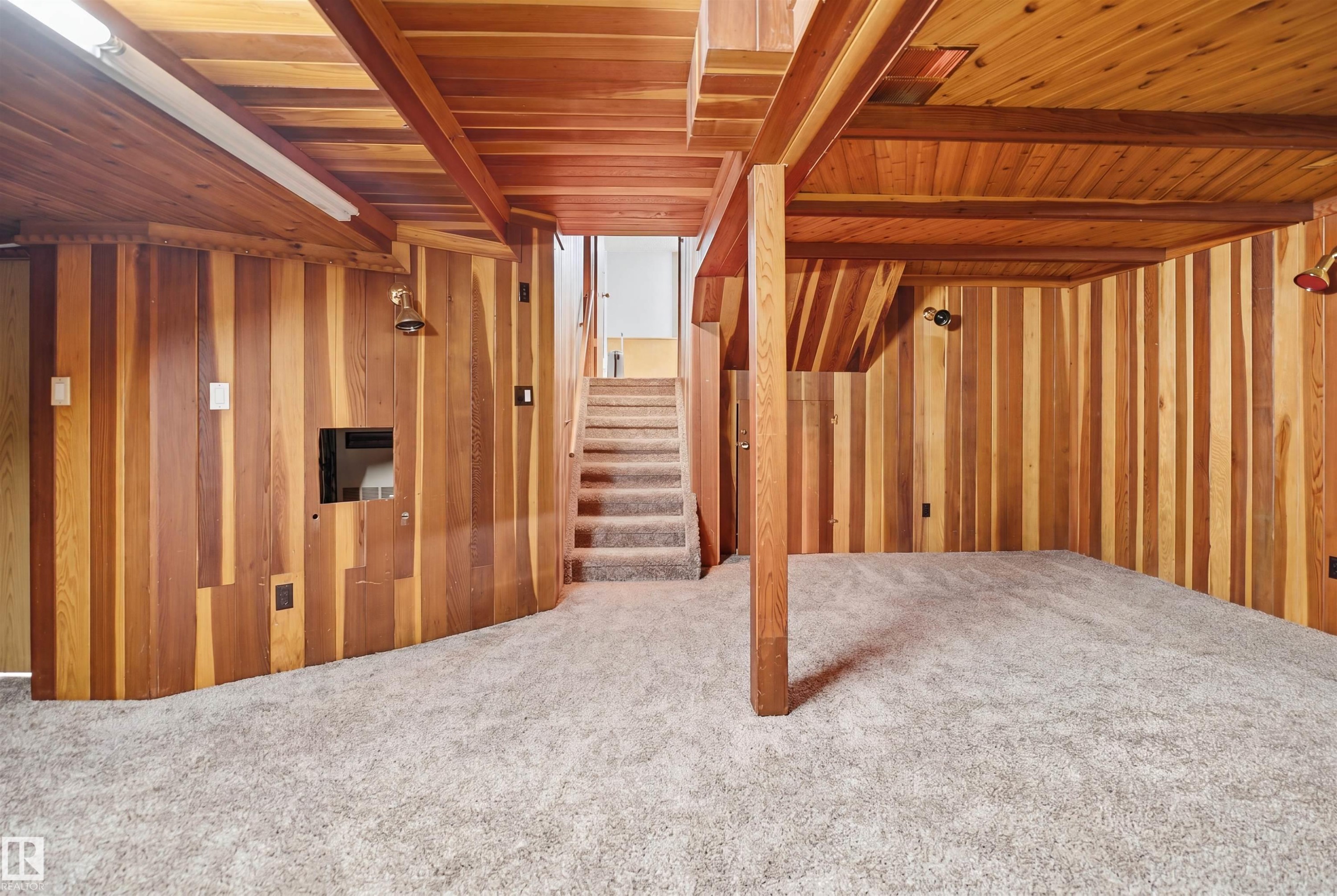 Finished lower level featuring vertical wood-paneled walls and ceiling beams - 3220 42A Avenue, Edmonton, AB