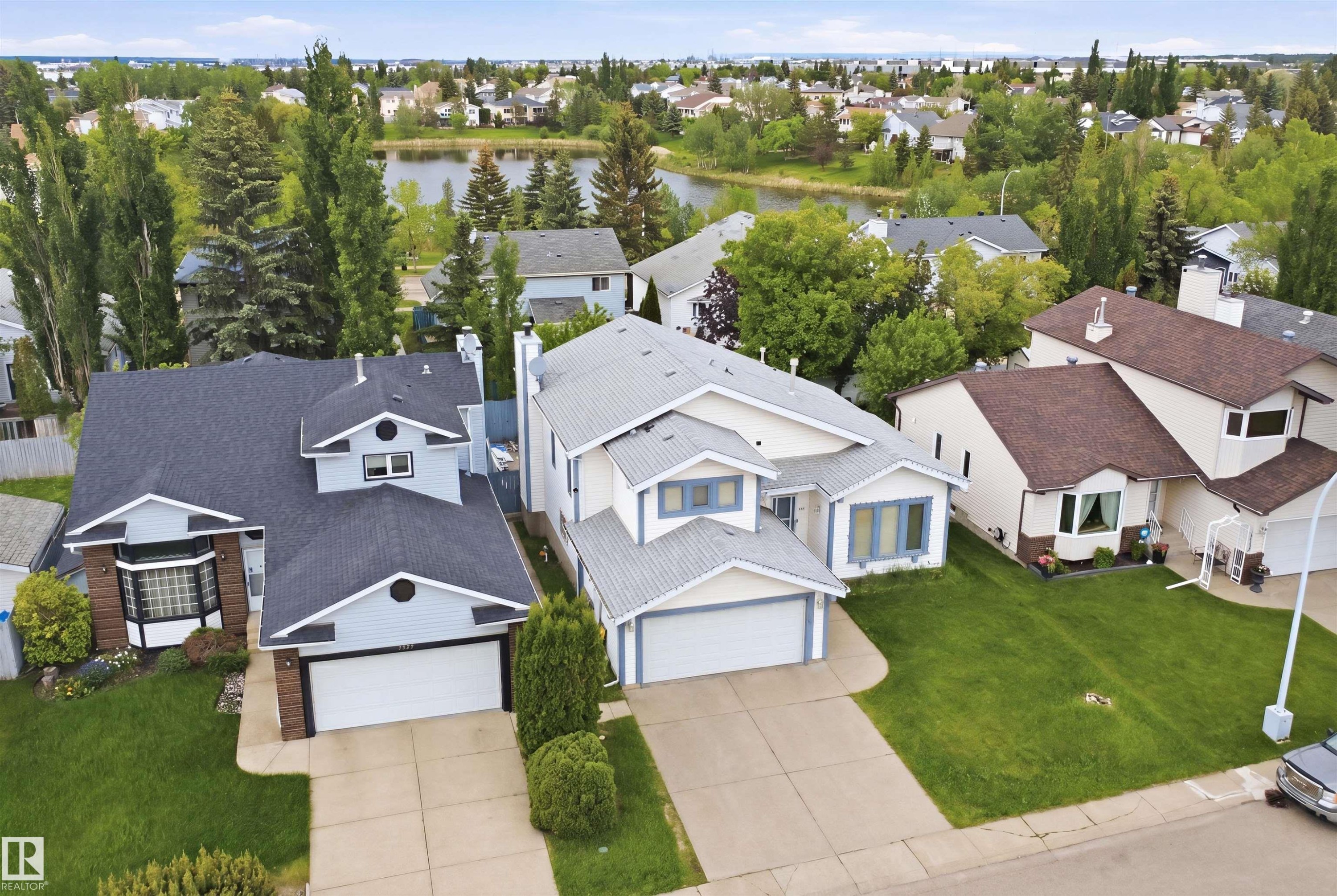 Aerial perspective showcasing the residential neighborhood with a prominent body of water and mature trees - 3220 42A Avenue, Edmonton, AB