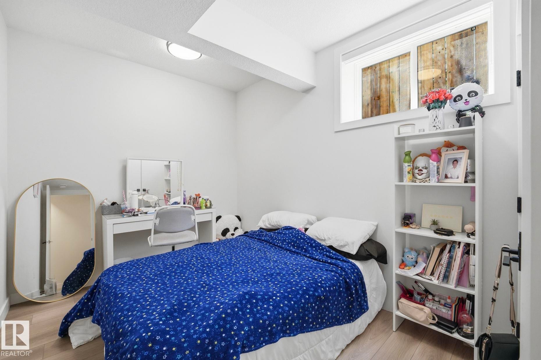 Bedroom space featuring light wood-finish flooring, white walls, and a recessed window - 11012 132 Street, Edmonton, AB