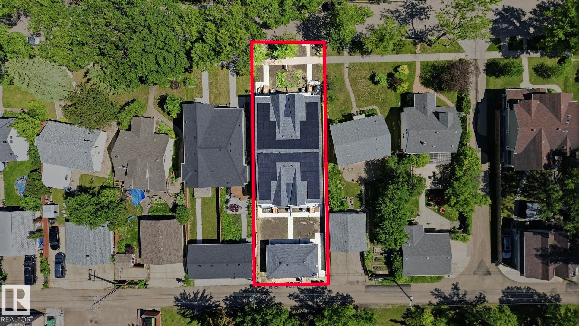 Aerial perspective showcasing a multi-unit property with a prominent solar panel array - 11012 132 Street, Edmonton, AB