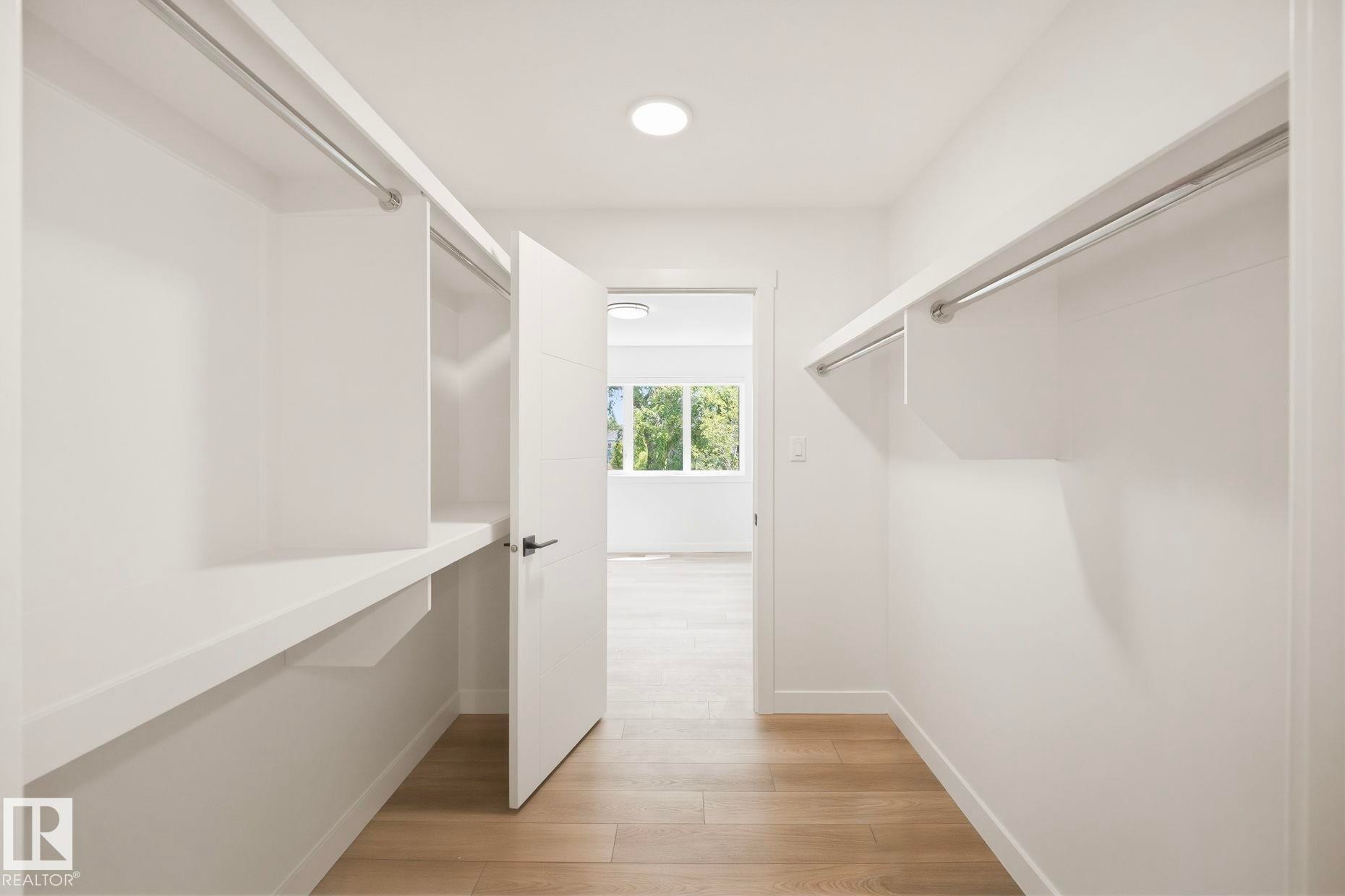 Walk-in closet with integrated shelving, hanging rods, and light wood-finish flooring - 11012 132 Street, Edmonton, AB