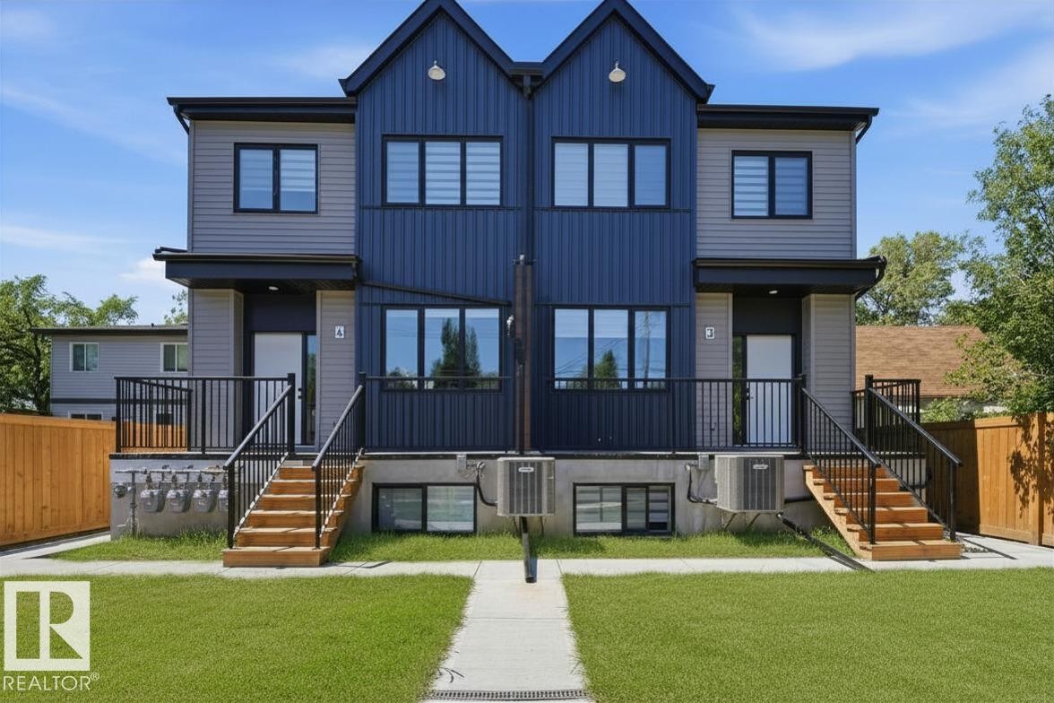 Modern duplex exterior featuring a two-tone facade with dark blue and gray siding - 11007 132 Street Nw, Edmonton, AB