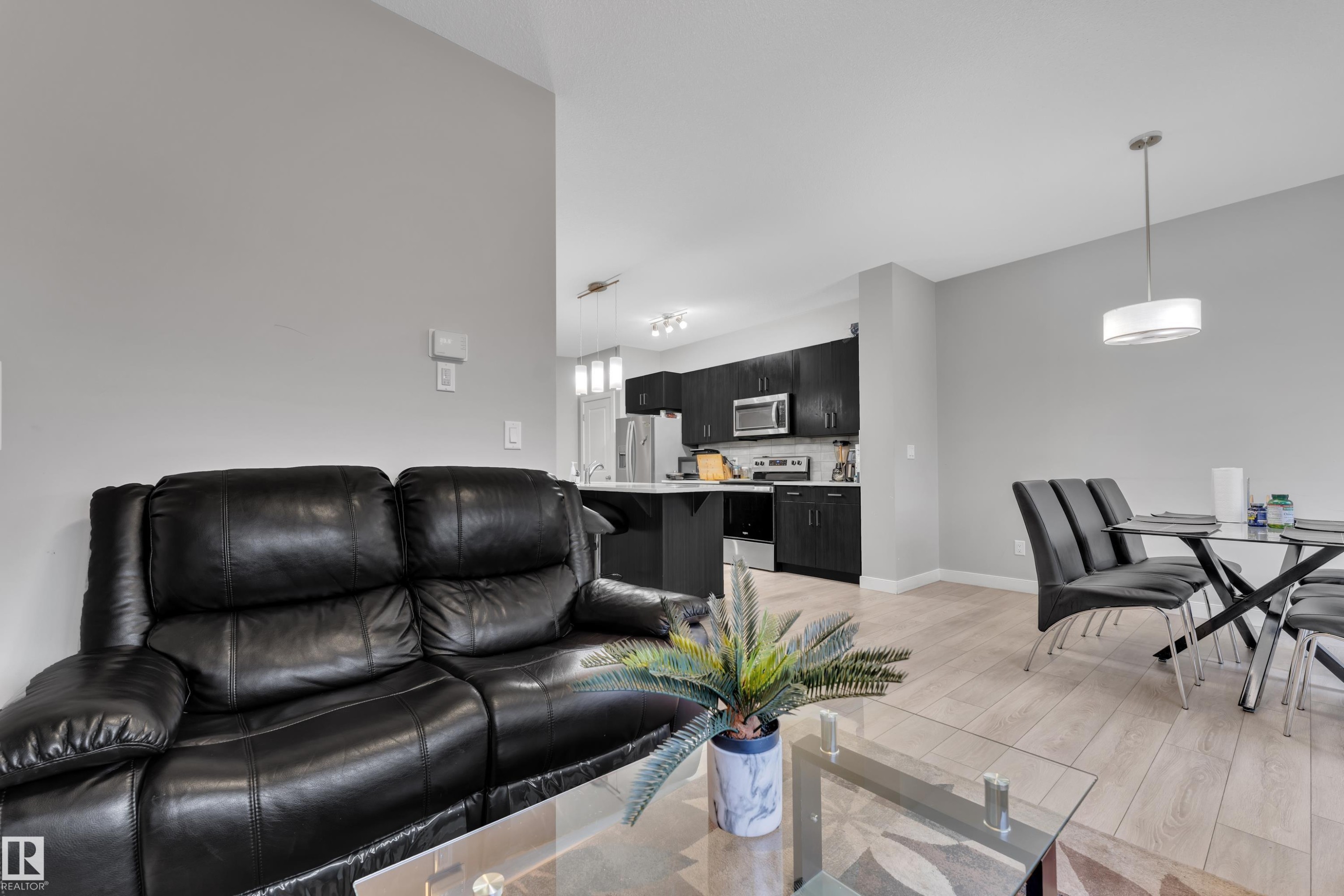 Open-concept living area featuring light wood-finish flooring, neutral wall tones, and recessed lighting - 9328 Pear Link Link, Edmonton, AB