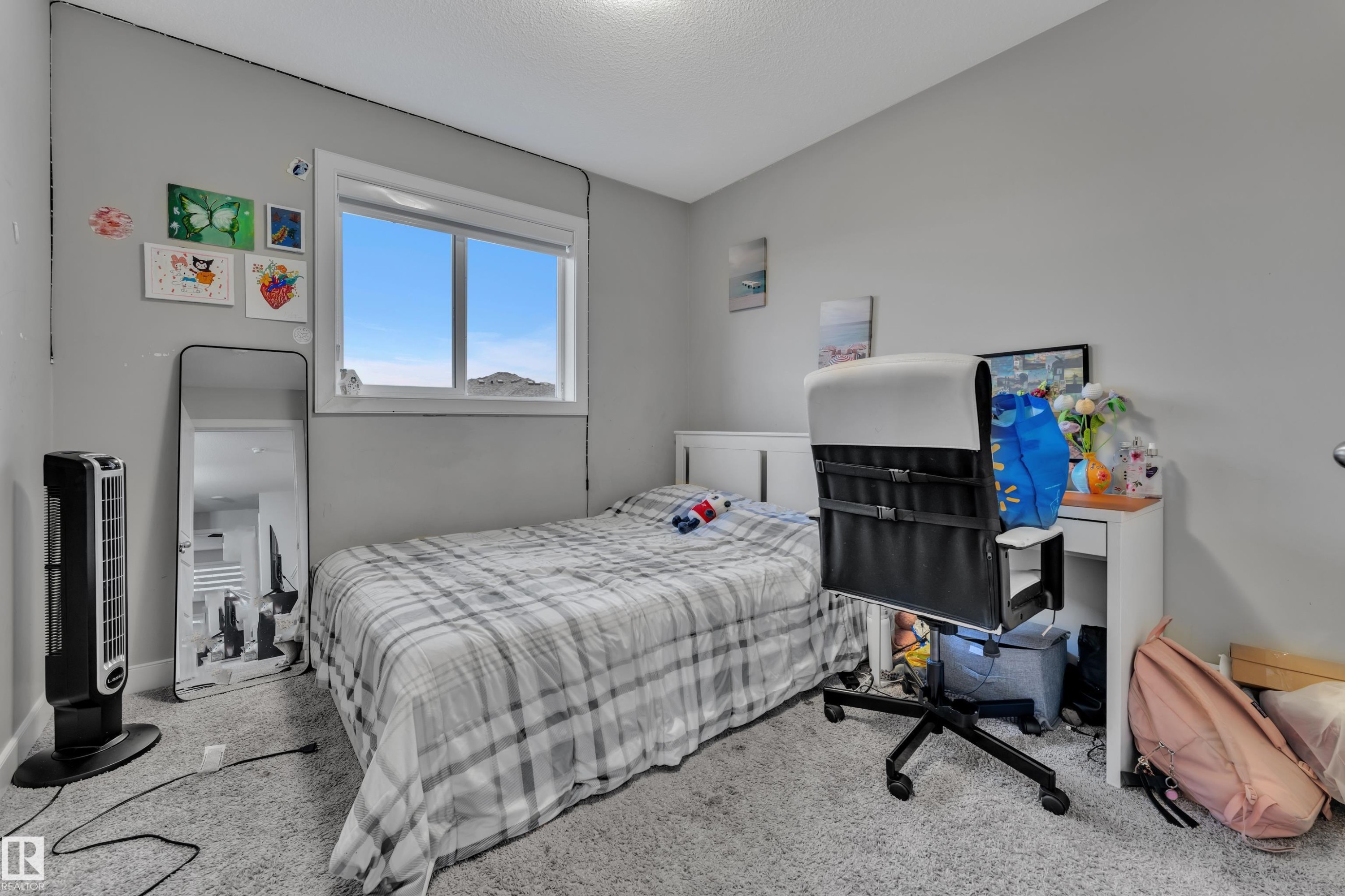 Well-lit room featuring a white-framed window, light gray walls, and textured carpeting - 9328 Pear Link Link, Edmonton, AB
