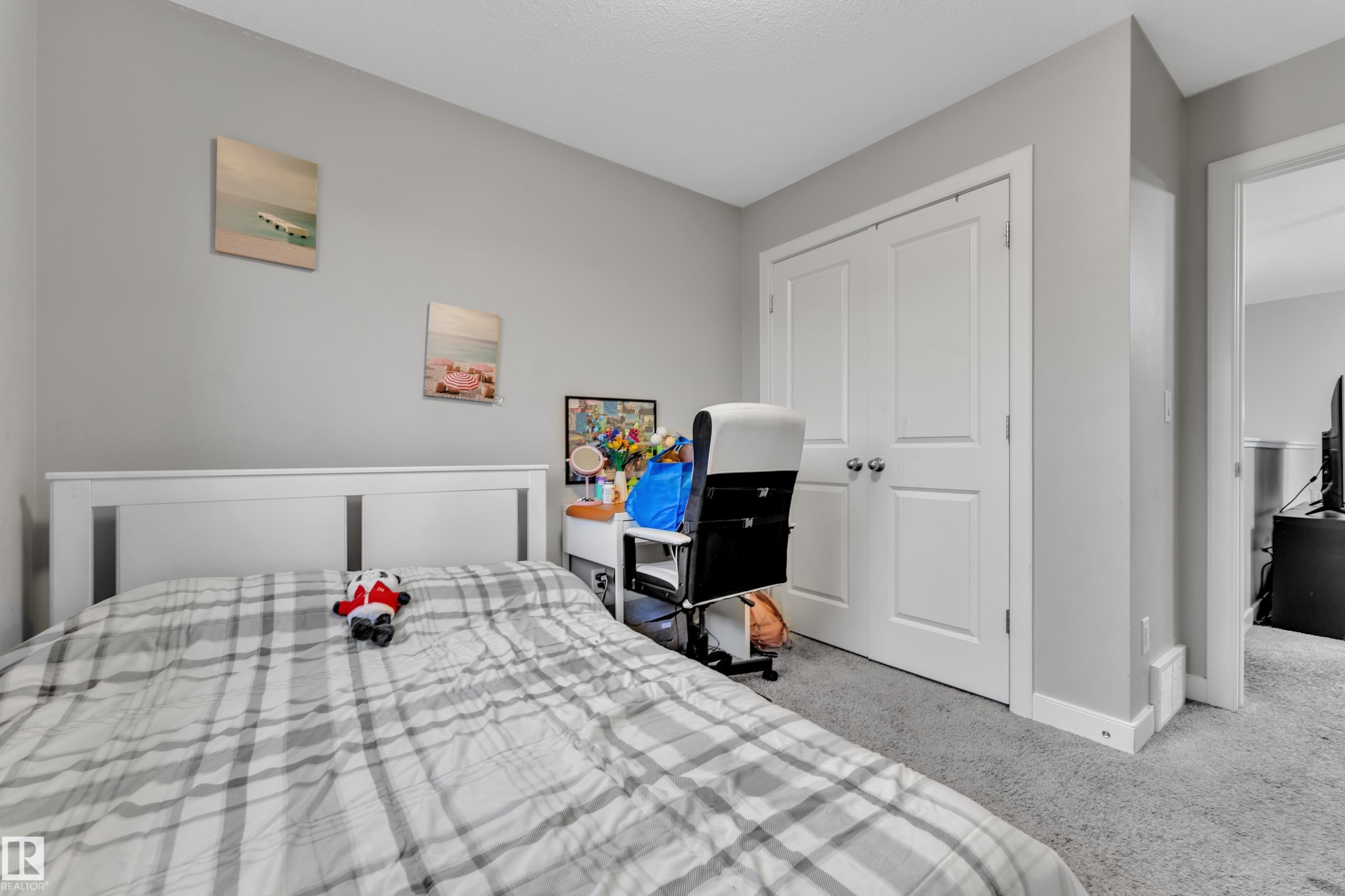 Bedroom featuring neutral gray wall paint, light gray carpeting, and a white paneled headboard - 9328 Pear Link Link, Edmonton, AB