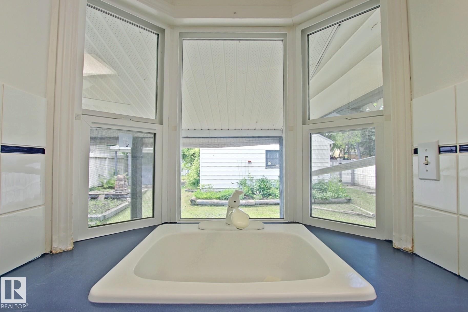 Integrated sink with a white faucet set into a blue countertop - 11242 56 Street, Edmonton, AB