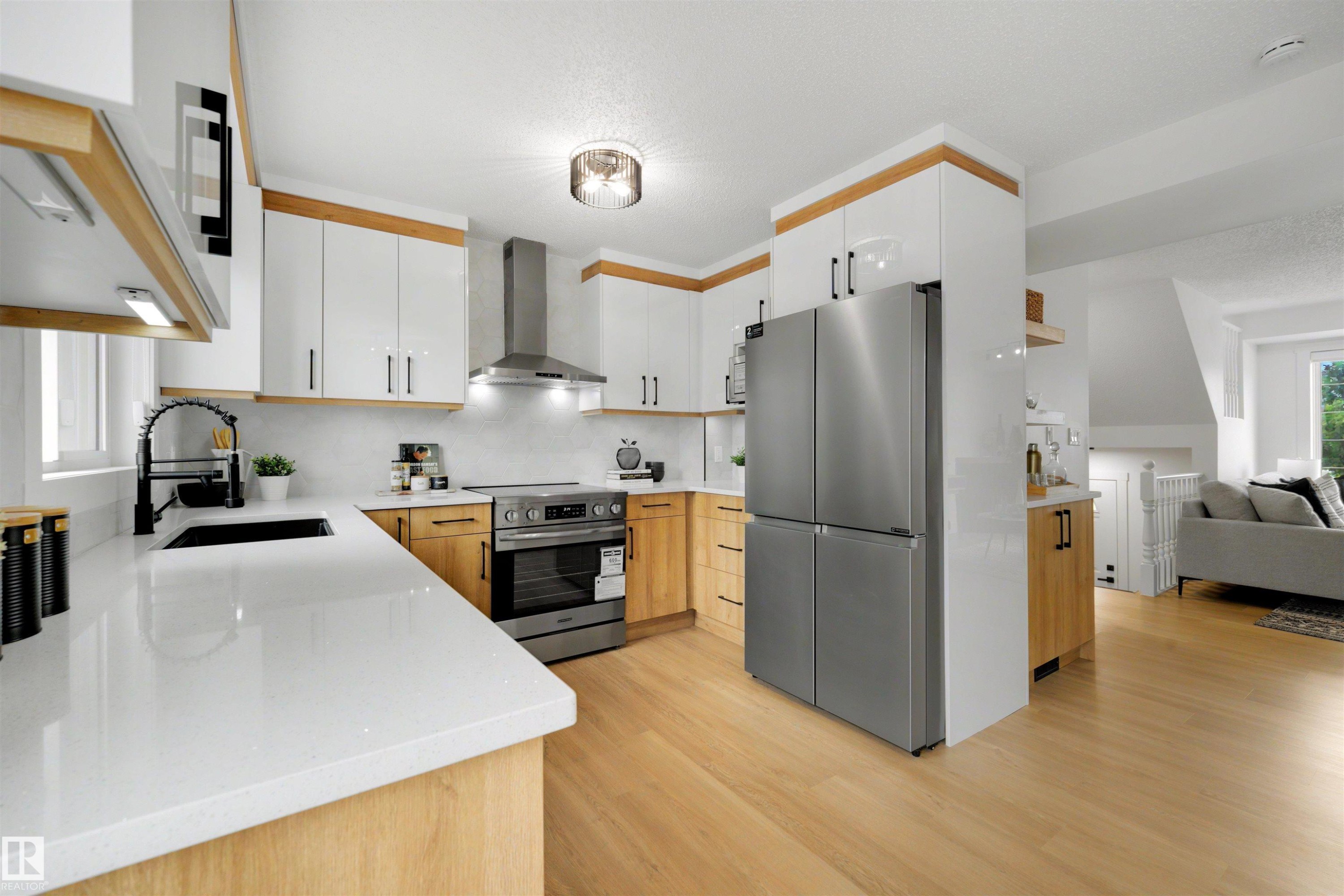 Modern kitchen featuring light wood-finish flooring, white countertops, and a stainless steel appliance suite - 12611 47 Street, Edmonton, AB
