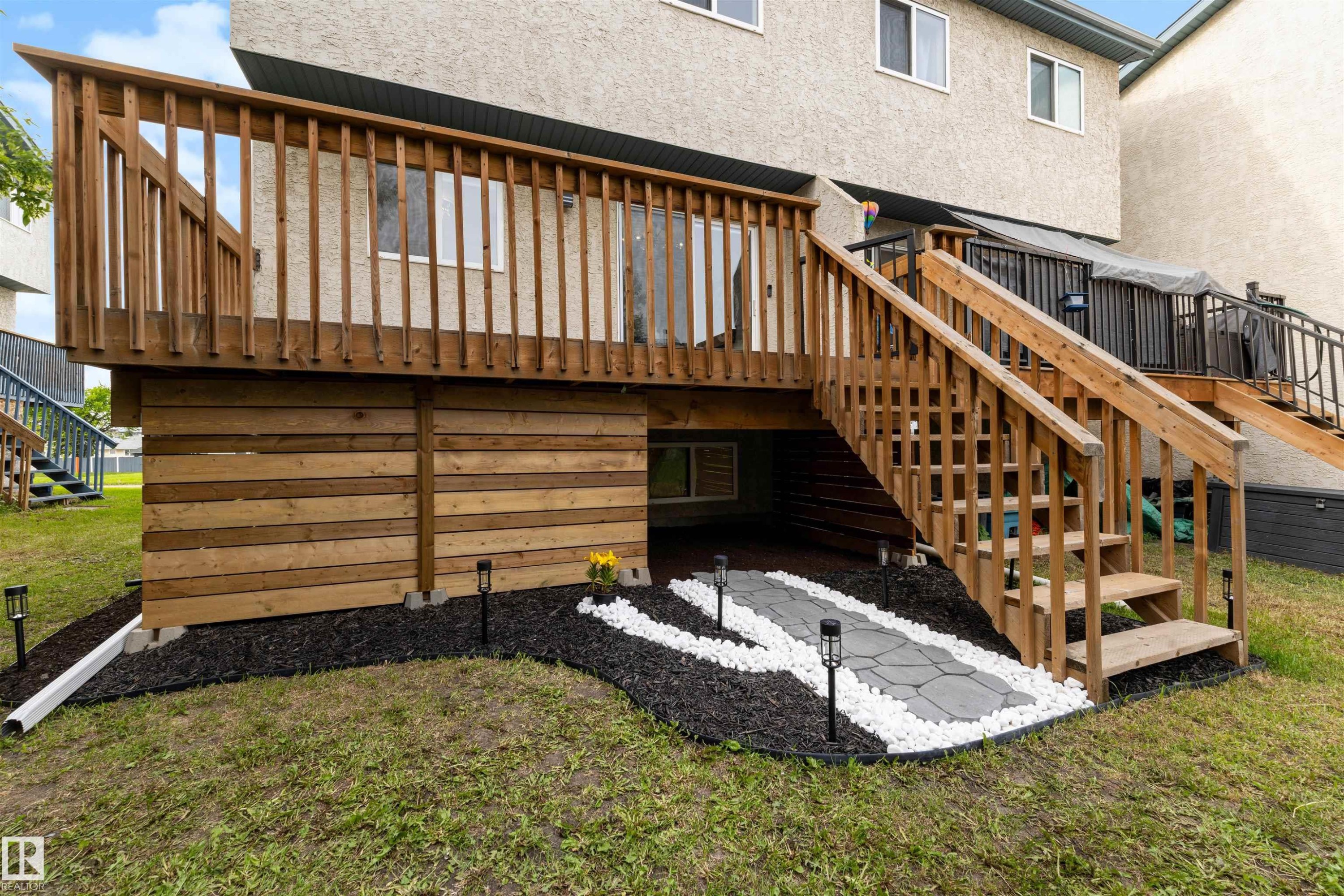 Elevated wood deck with baluster railing and staircase - 12611 47 Street, Edmonton, AB