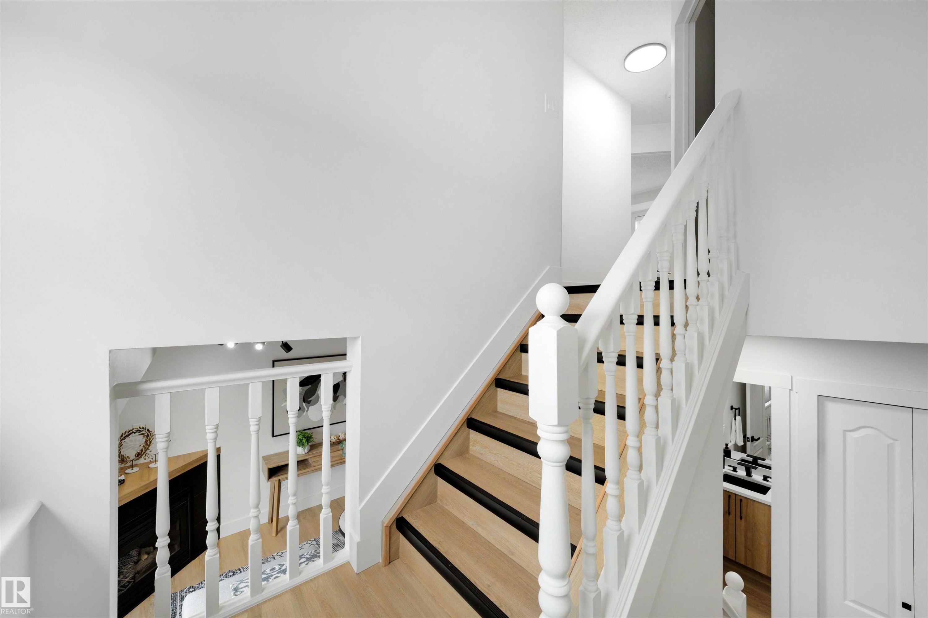 Hardwood staircase with white balusters and dark stair treads - 12611 47 Street, Edmonton, AB