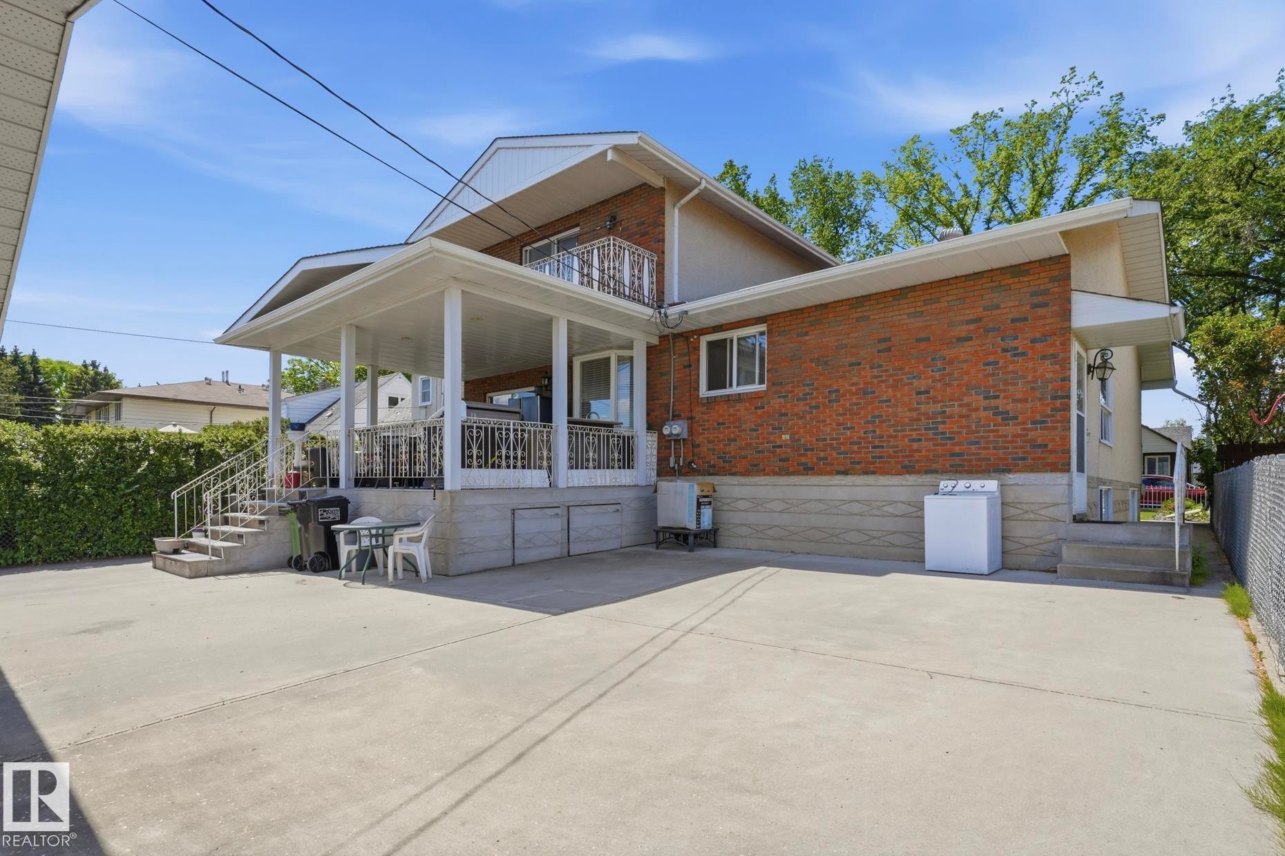 Expansive concrete driveway leading to a covered patio - 12131 101 Street Nw, Edmonton, AB