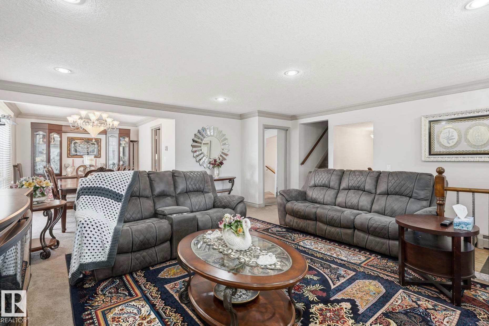 Spacious living area featuring neutral wall tones, recessed lighting, and crown molding - 12131 101 Street Nw, Edmonton, AB