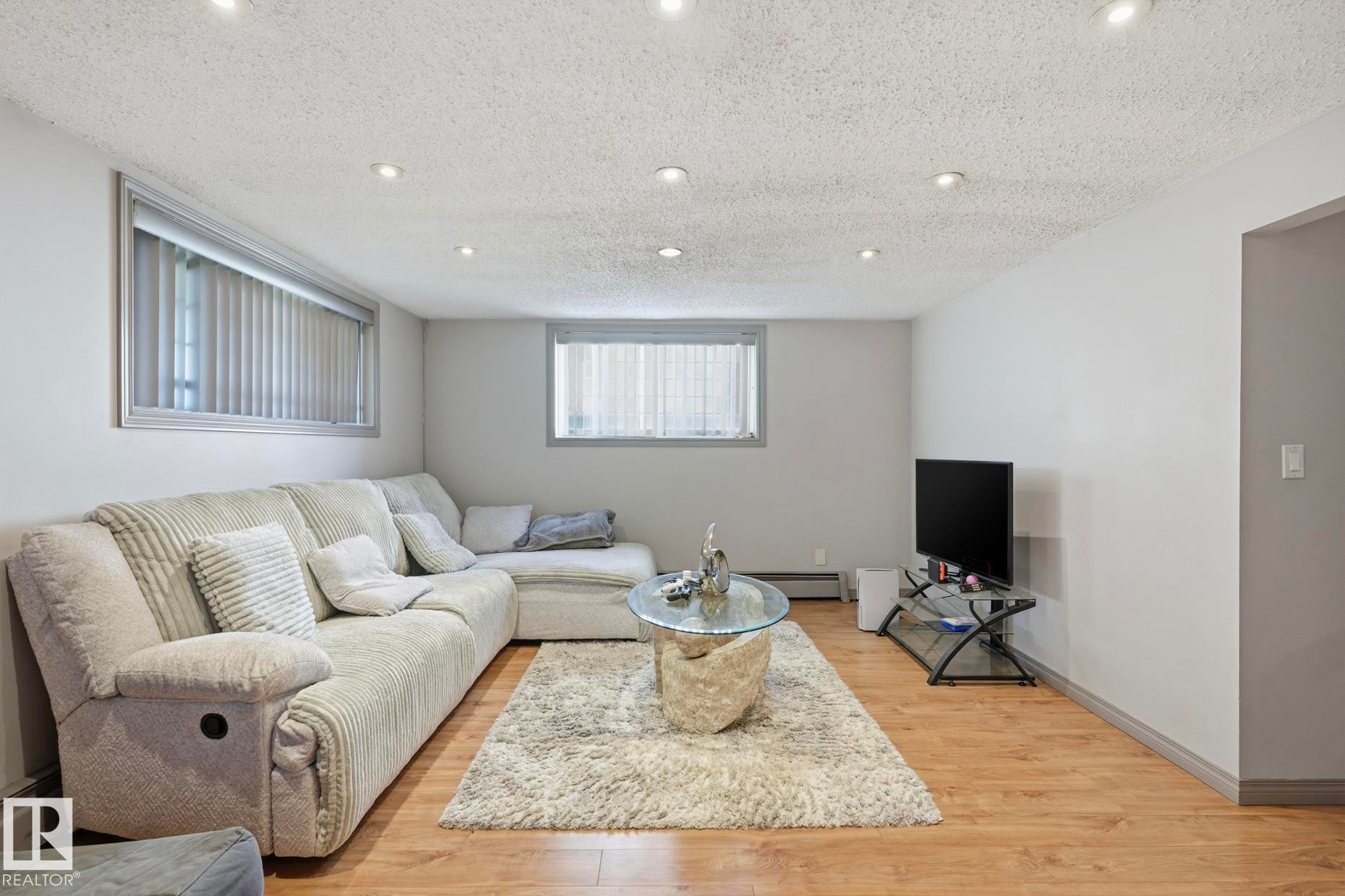 Living area featuring recessed lighting, light wood-finish flooring, and neutral wall tones - 12131 101 Street Nw, Edmonton, AB