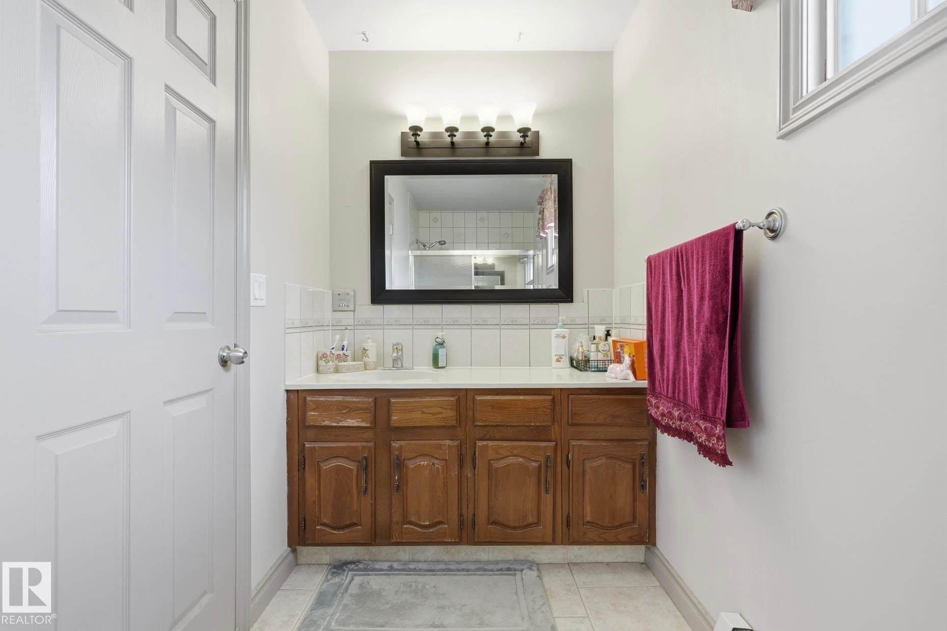 Bathroom with a wood-finish vanity and integrated sink - 12131 101 Street Nw, Edmonton, AB